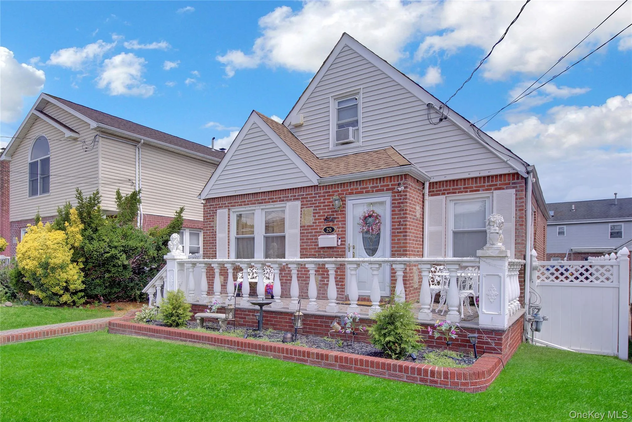 Brick facade with white siding accents and a pitched roofline Brick facade with white siding accents and a pitched roofline