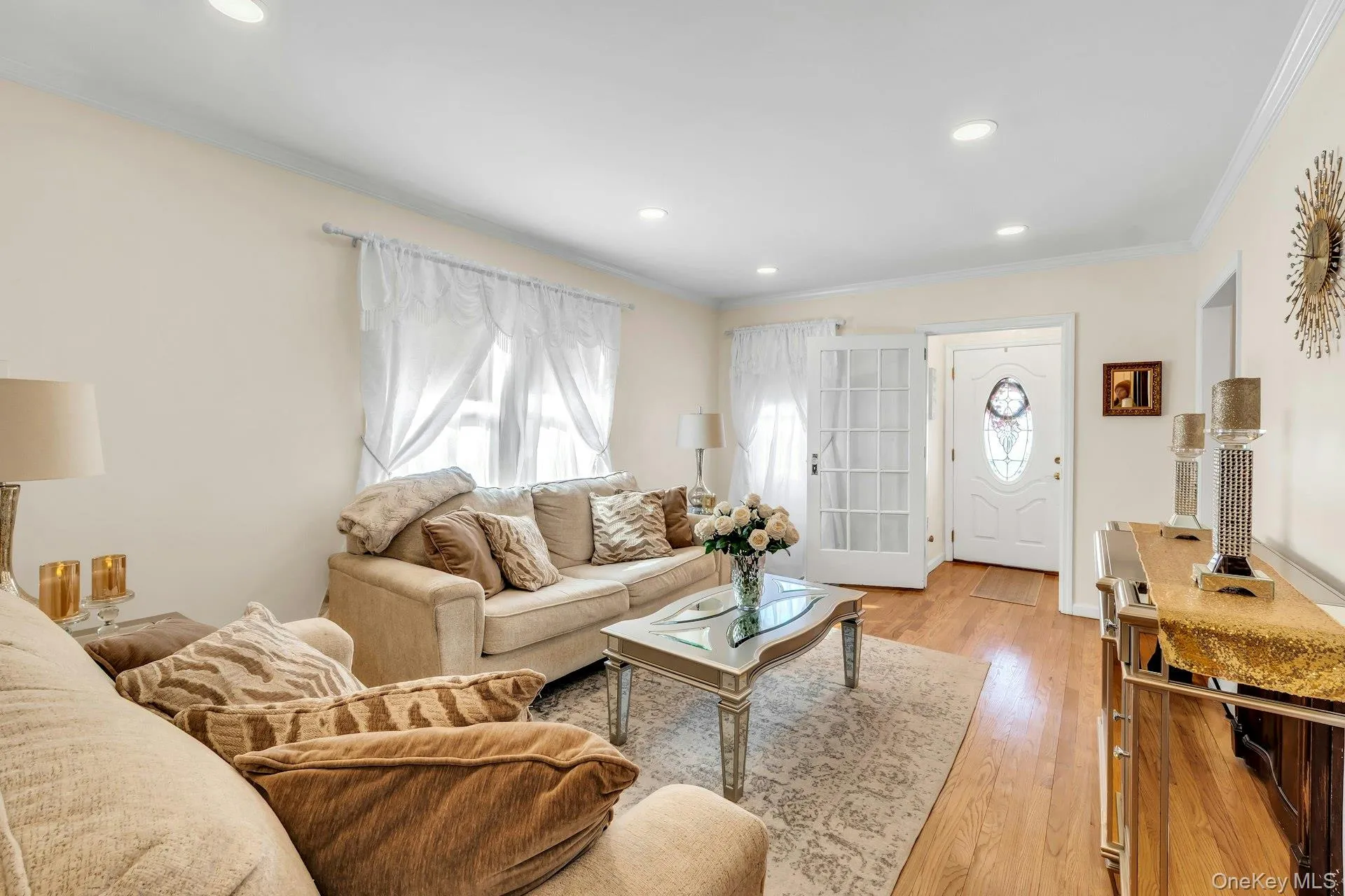 Living area featuring recessed lighting, hardwood flooring, and light-toned wall finishes Living area featuring recessed lighting, hardwood flooring, and light-toned wall finishes