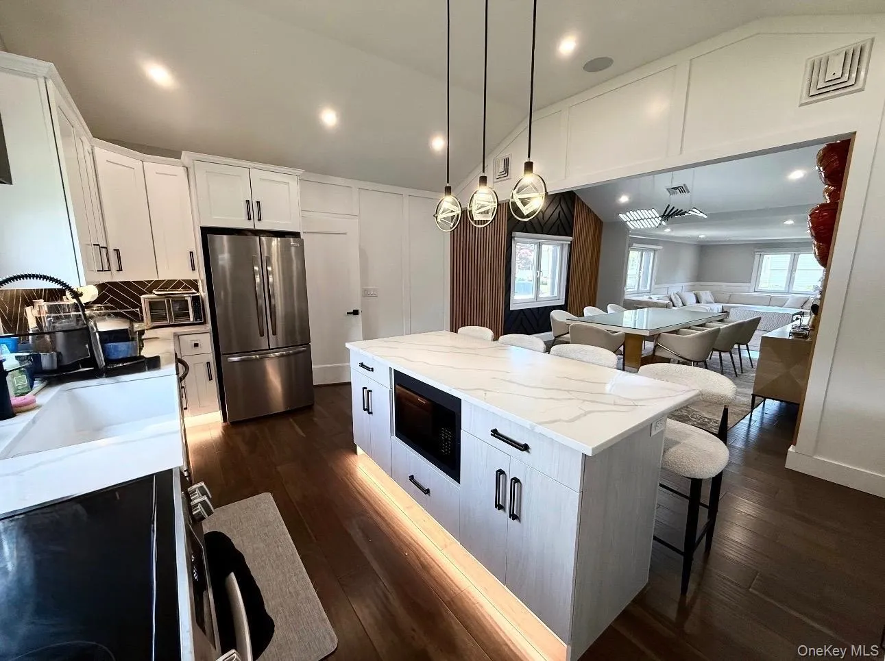 Gourmet kitchen featuring a substantial center island with quartz countertop and integrated microwave Gourmet kitchen featuring a substantial center island with quartz countertop and integrated microwave