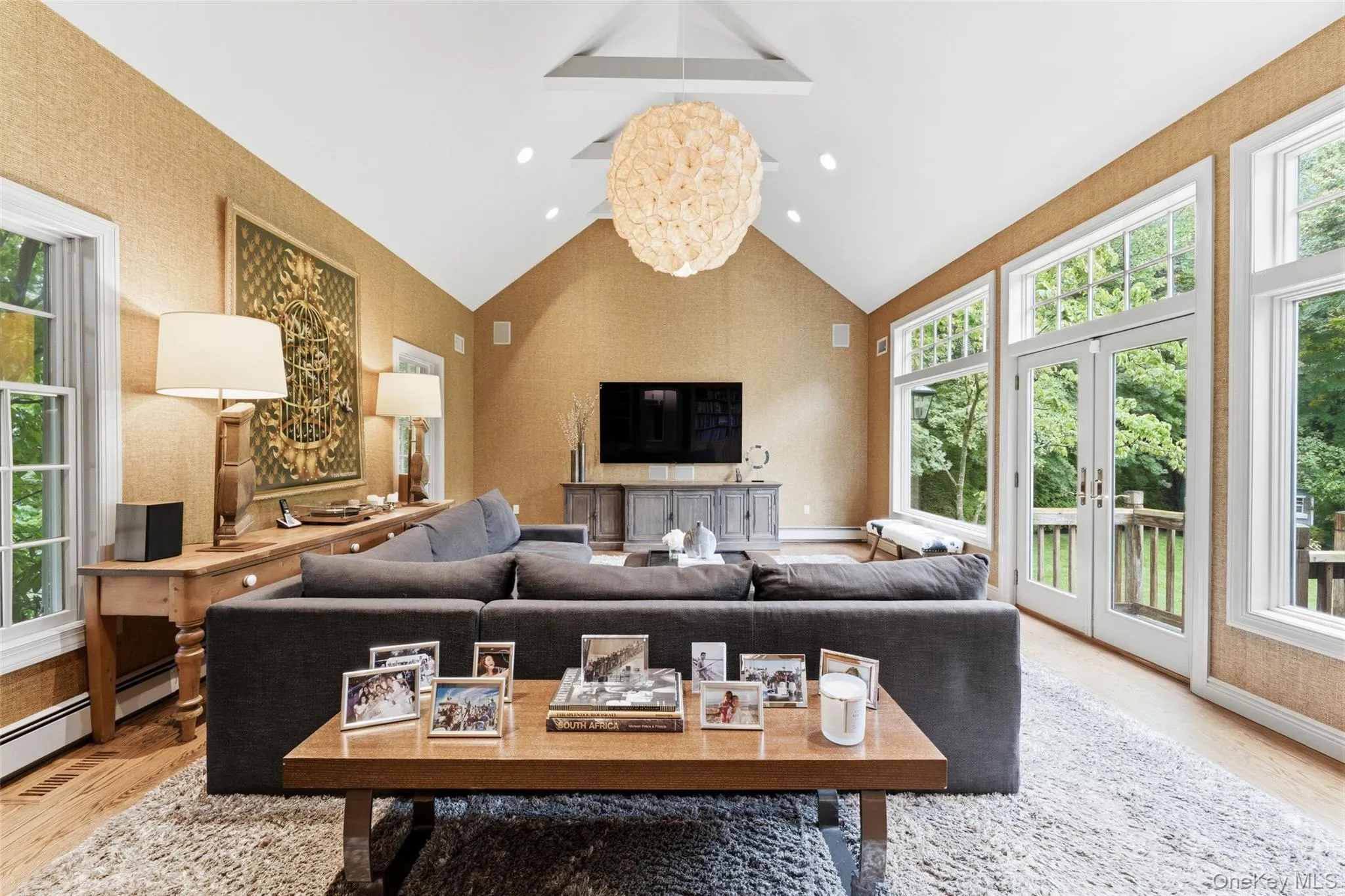 Large family room with vaulted ceiling and wall of windows overlooking the backyard Large family room with vaulted ceiling and wall of windows overlooking the backyard