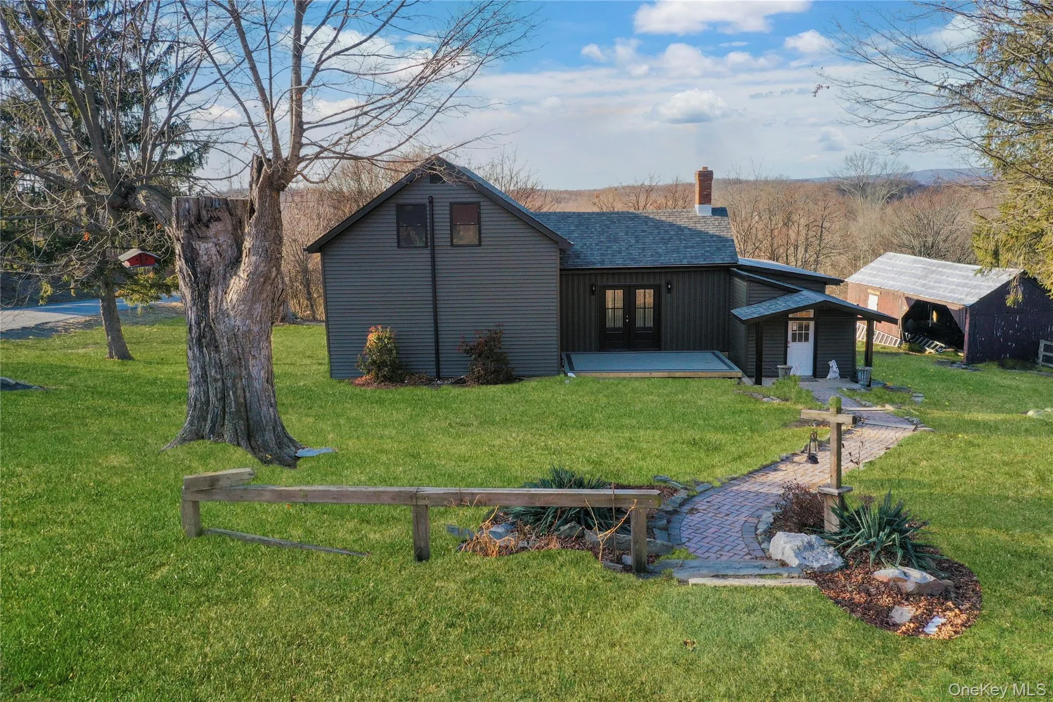 Rear view of house featuring a lawn, a chimney, and a deck Rear view of house featuring a lawn, a chimney, and a deck