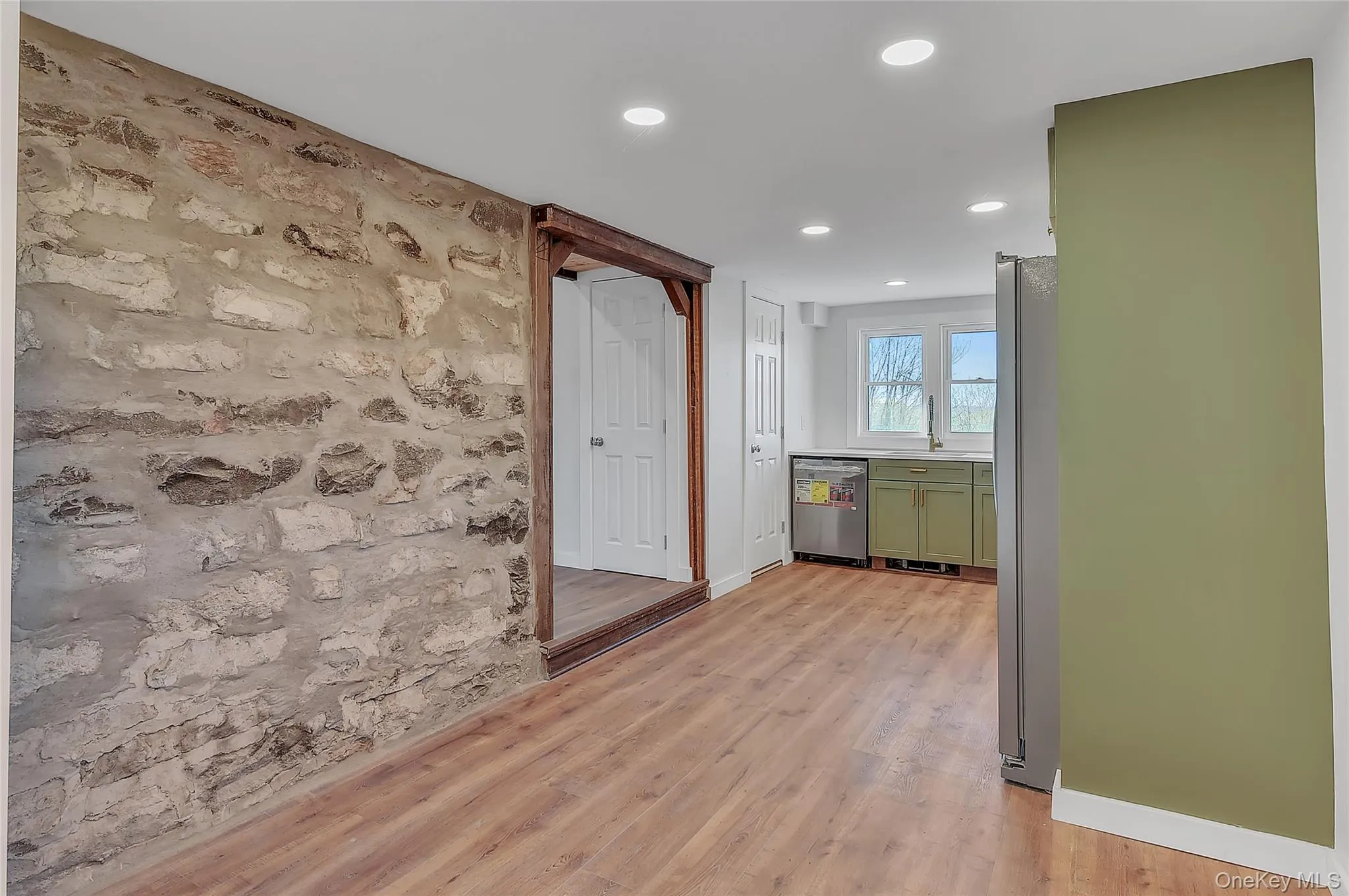 Hall with an accent wall, light wood-type flooring, and recessed lighting Hall with an accent wall, light wood-type flooring, and recessed lighting