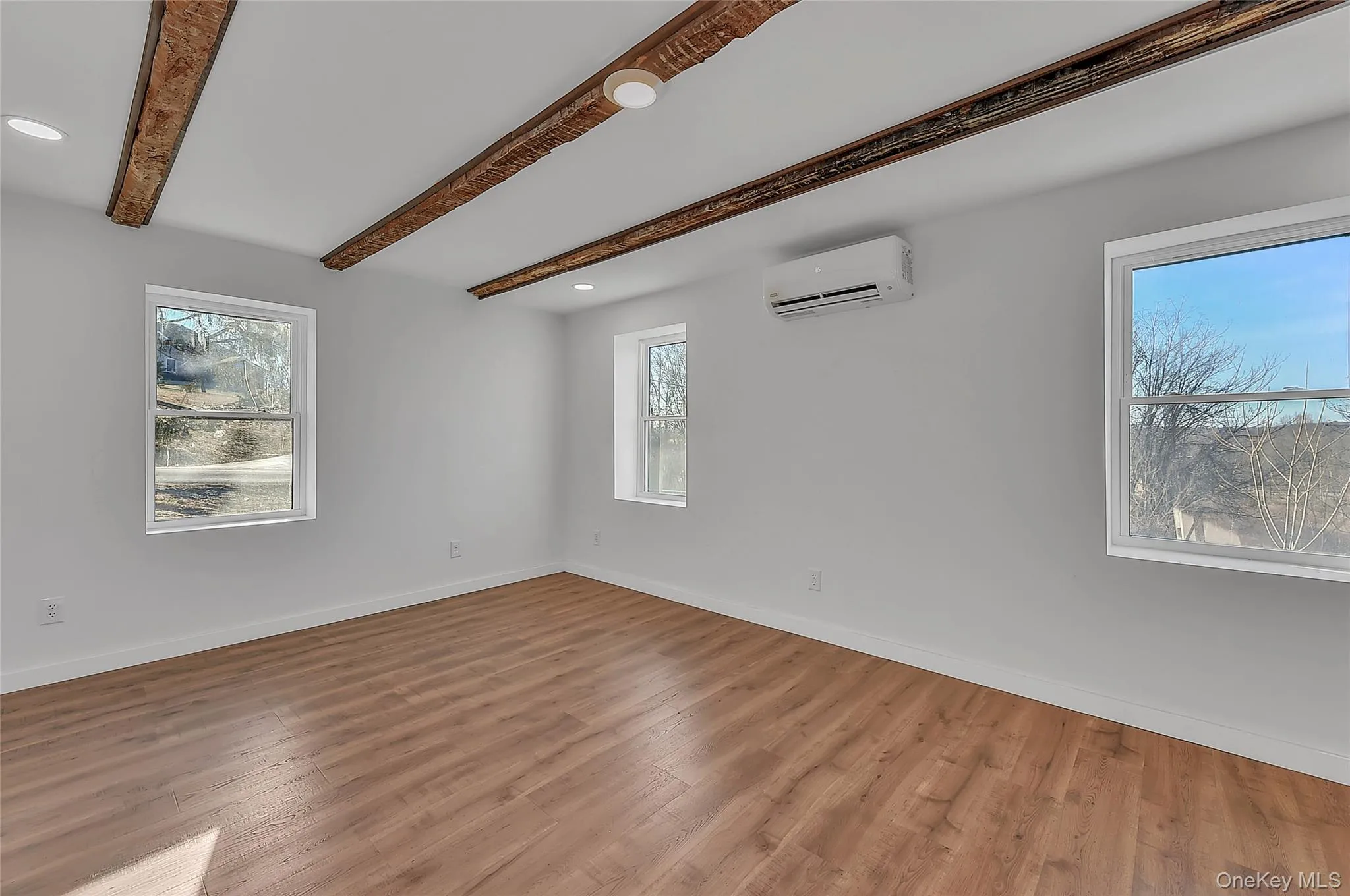 Spare room with beamed ceiling, wood finished floors, recessed lighting, and a wall unit AC Spare room with beamed ceiling, wood finished floors, recessed lighting, and a wall unit AC