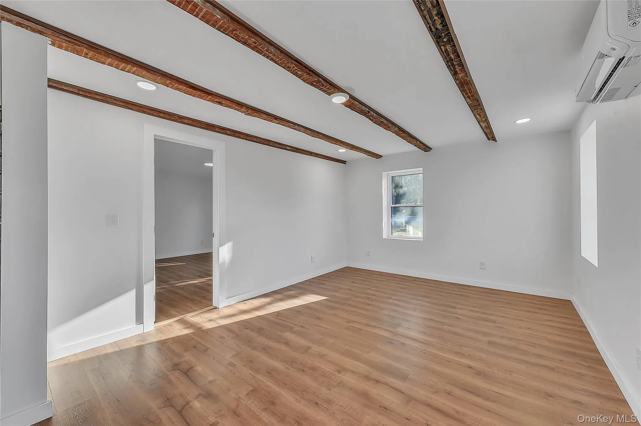 Spare room featuring recessed lighting, beamed ceiling, cooling unit, and light wood-style flooring Spare room featuring recessed lighting, beamed ceiling, cooling unit, and light wood-style flooring