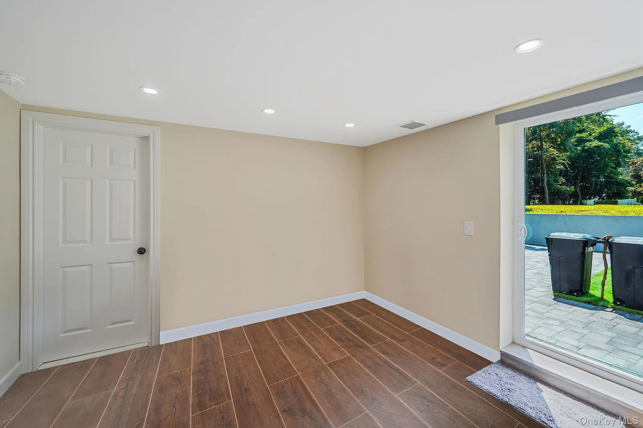 Empty room featuring dark wood-style flooring and recessed lighting Empty room featuring dark wood-style flooring and recessed lighting