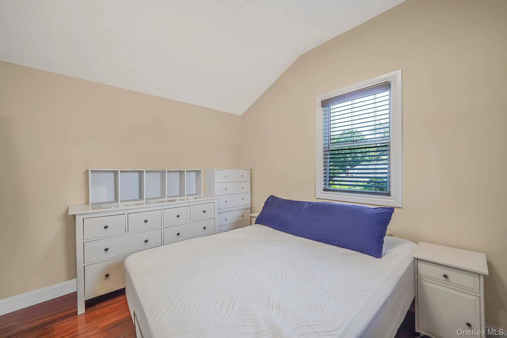 Bedroom featuring vaulted ceiling and dark wood-style flooring Bedroom featuring vaulted ceiling and dark wood-style flooring