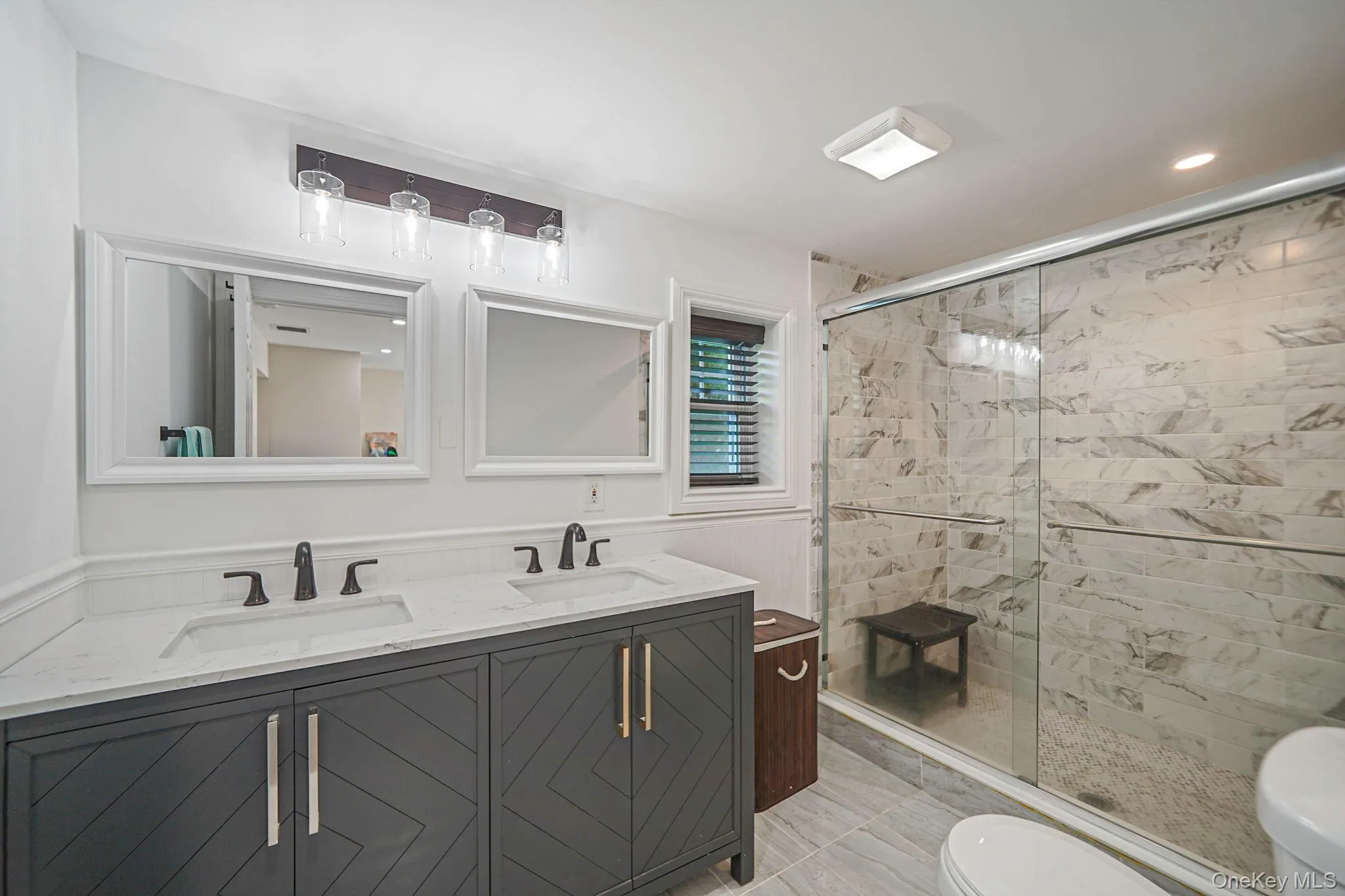 Bathroom featuring double vanity, marble finish floors, a stall shower, and recessed lighting Bathroom featuring double vanity, marble finish floors, a stall shower, and recessed lighting
