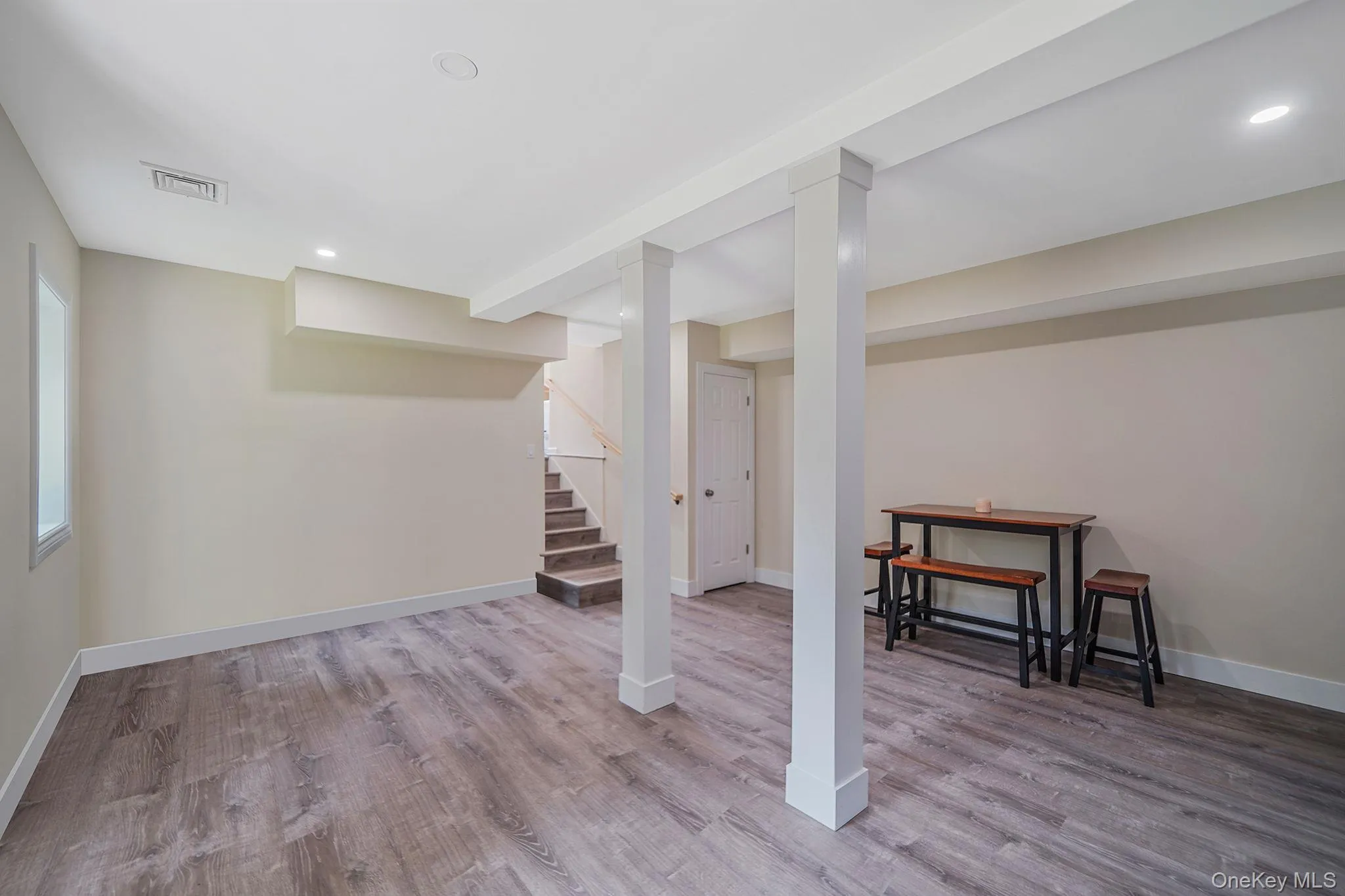 Finished below grade area with wood finished floors, stairway, and recessed lighting Finished below grade area with wood finished floors, stairway, and recessed lighting
