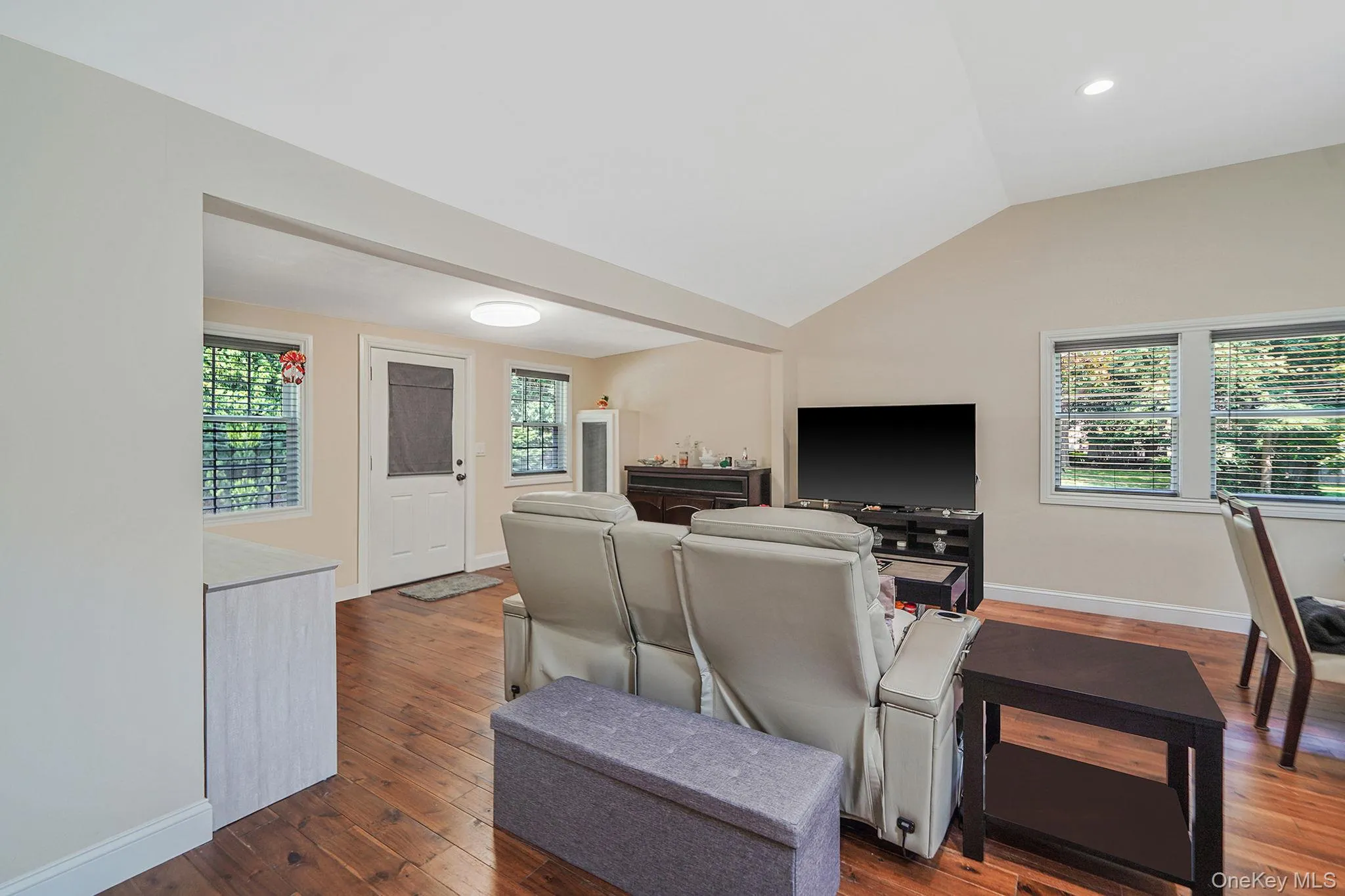 Living area with lofted ceiling and dark wood-style floors Living area with lofted ceiling and dark wood-style floors