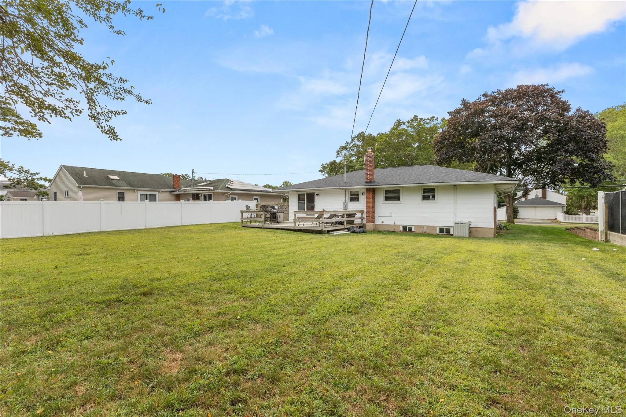 Rear view of property with a wooden deck and a chimney Rear view of property with a wooden deck and a chimney