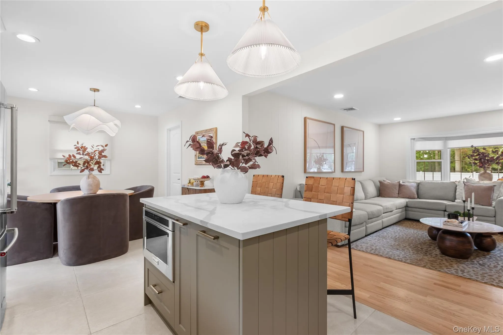 Kitchen featuring open floor plan, recessed lighting, a kitchen island, light stone counters, and hanging light fixtures Kitchen featuring open floor plan, recessed lighting, a kitchen island, light stone counters, and hanging light fixtures