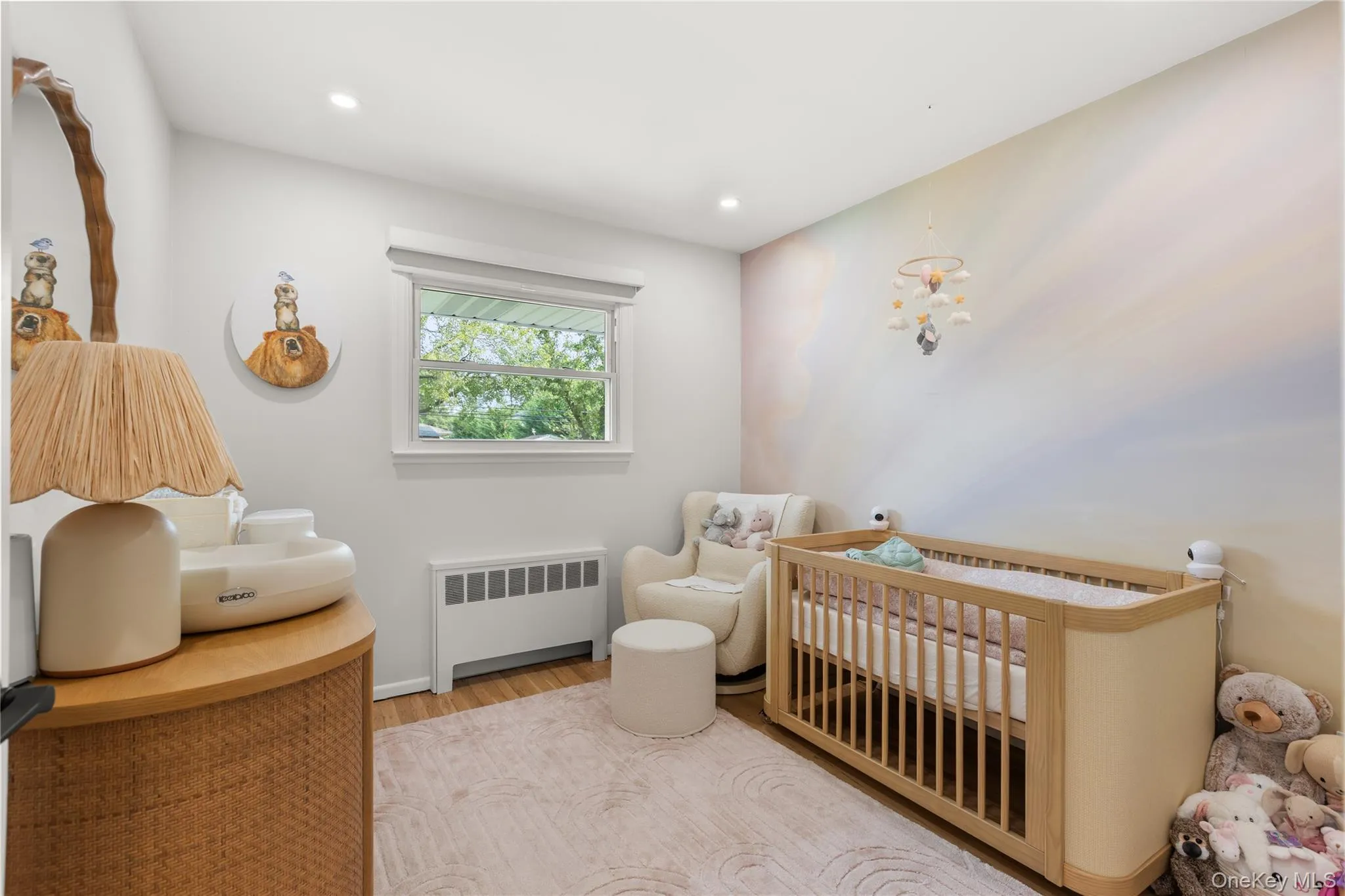 Bedroom featuring radiator, a nursery area, wood finished floors, and recessed lighting Bedroom featuring radiator, a nursery area, wood finished floors, and recessed lighting