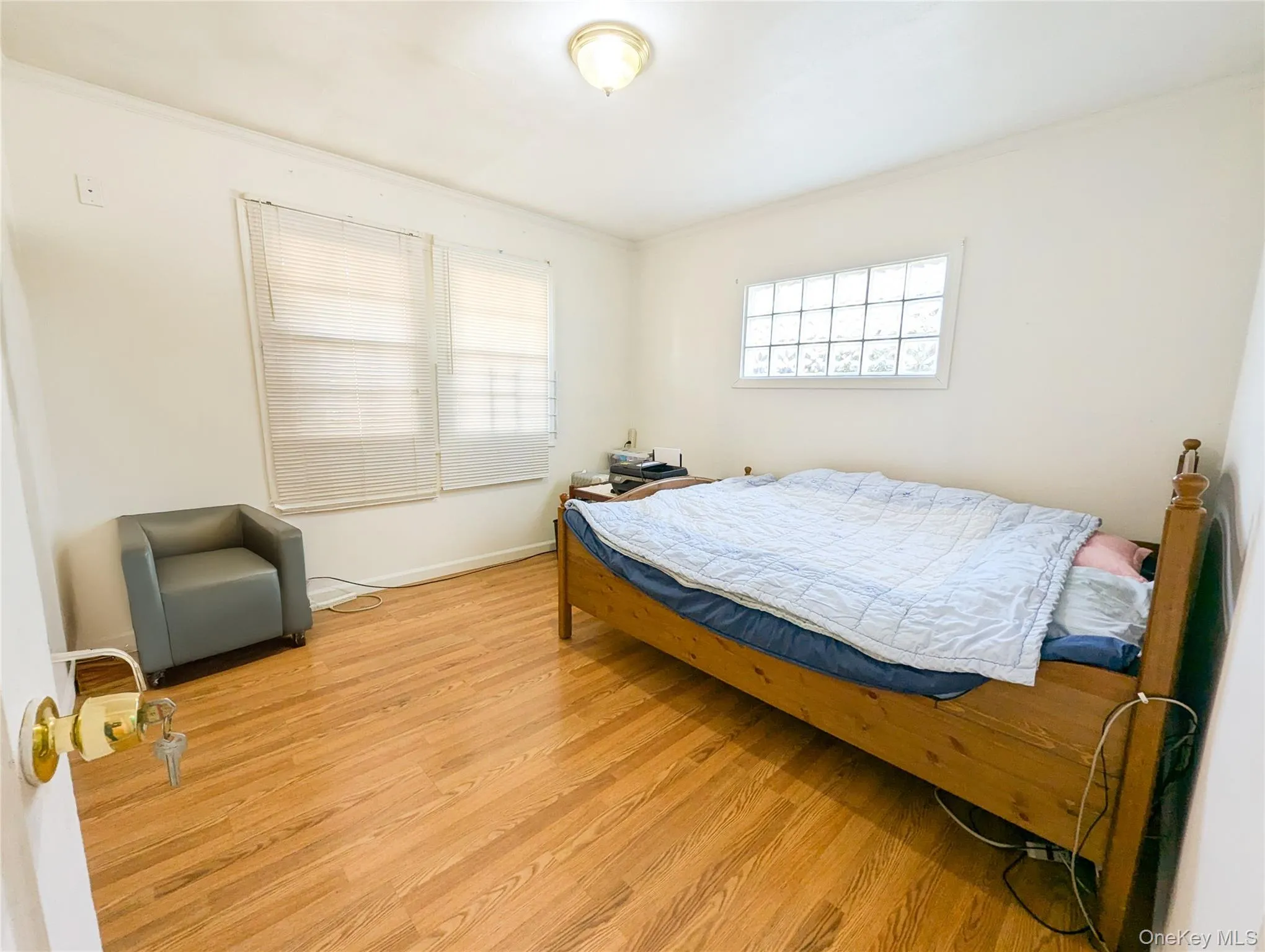 Bedroom with light hardwood / wood-style floors and crown molding Bedroom with light hardwood / wood-style floors and crown molding