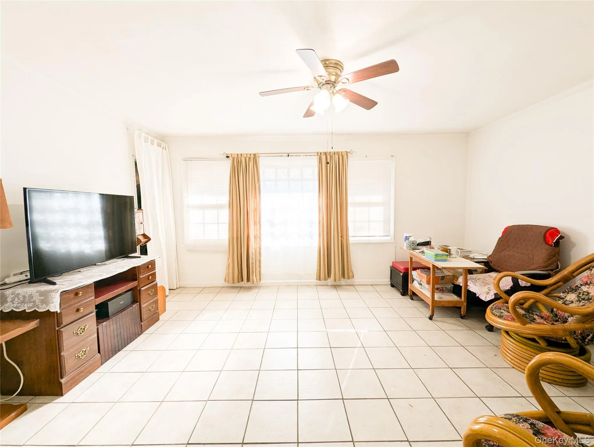 Sitting room featuring ceiling fan and light tile patterned flooring Sitting room featuring ceiling fan and light tile patterned flooring