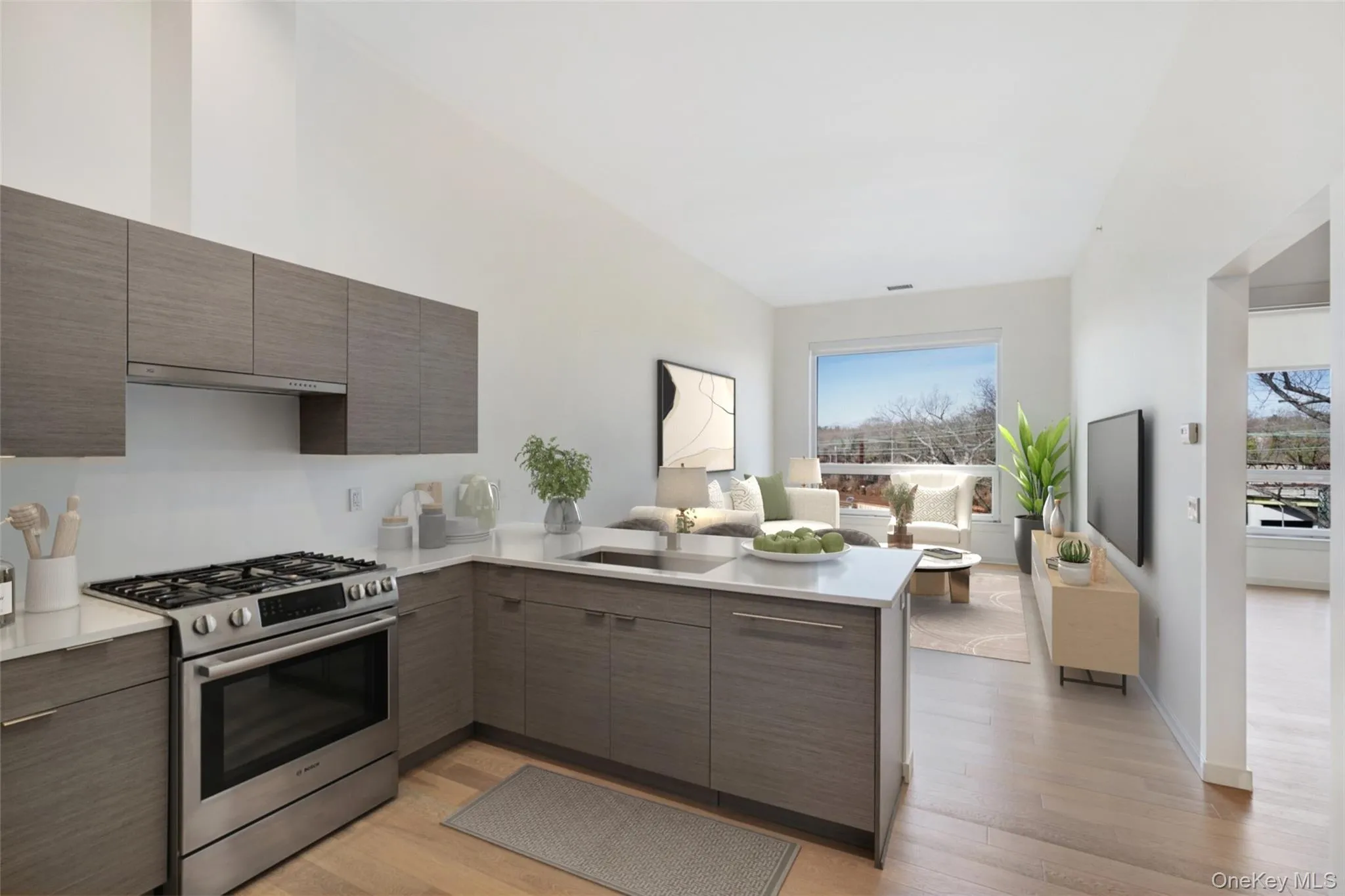 Kitchen with modern cabinets, a sink, a peninsula, light countertops, and stainless steel range with gas stovetop Kitchen with modern cabinets, a sink, a peninsula, light countertops, and stainless steel range with gas stovetop