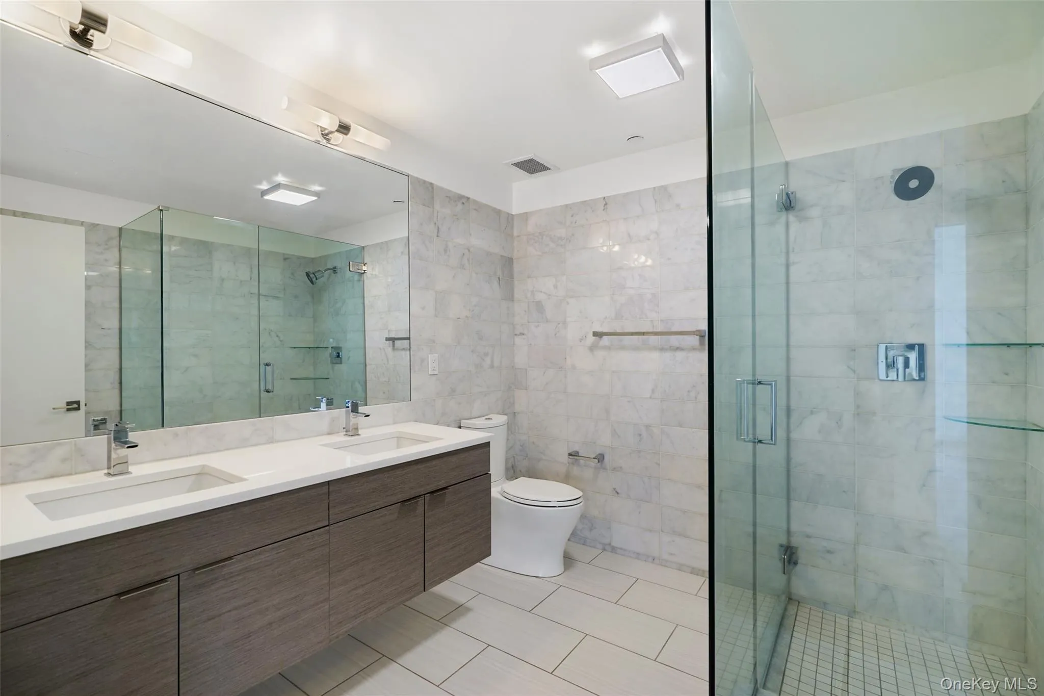 Full bath with a shower stall, toilet, and a sink Full bath with a shower stall, toilet, and a sink