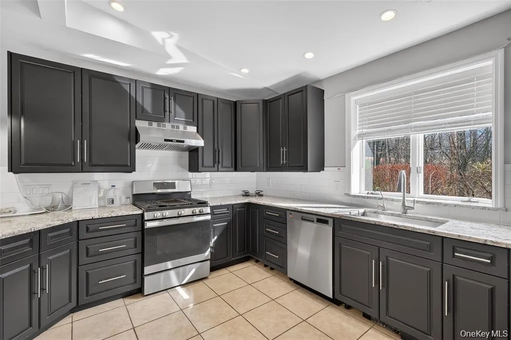 Kitchen with stainless steel appliances, light stone counters, recessed lighting, light tile patterned floors, and backsplash Kitchen with stainless steel appliances, light stone counters, recessed lighting, light tile patterned floors, and backsplash