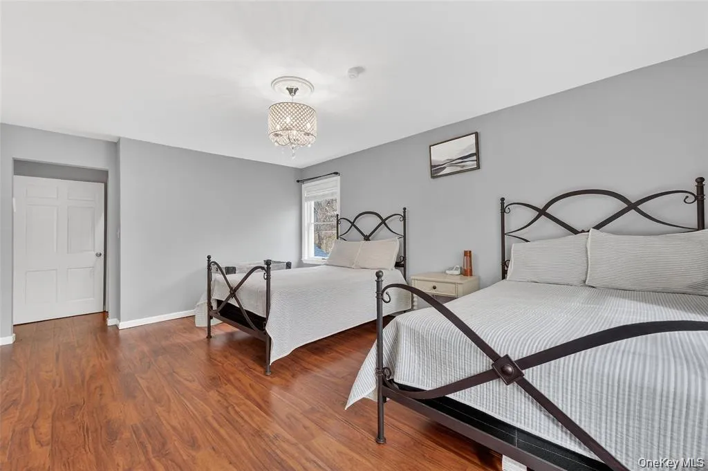 Bedroom featuring wood finished floors and a chandelier Bedroom featuring wood finished floors and a chandelier