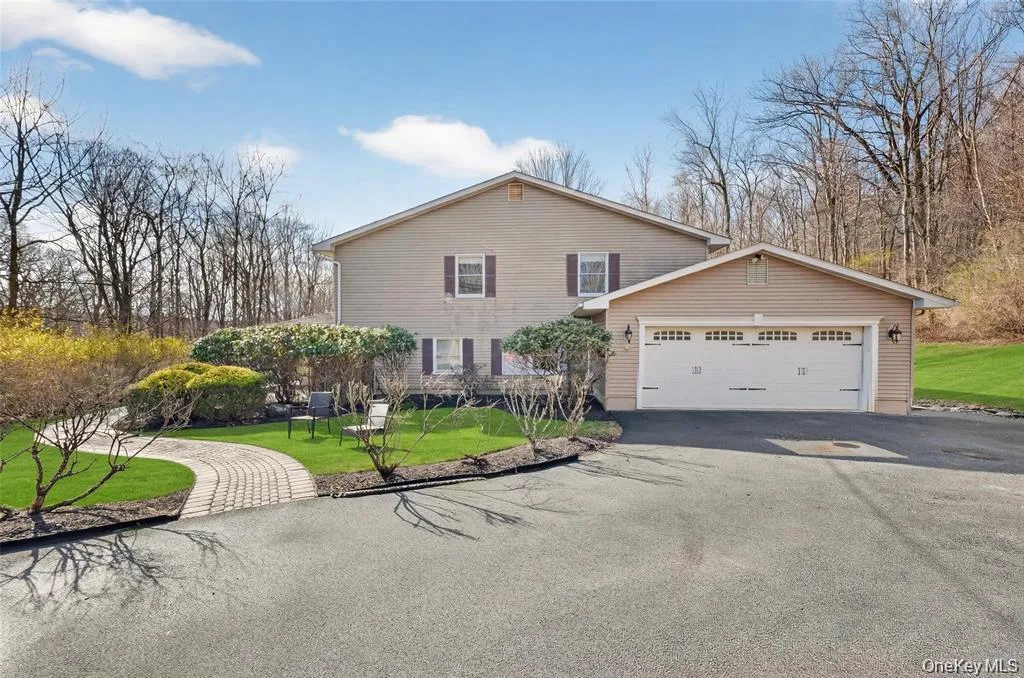 Traditional-style house with a front yard, an attached garage, and driveway Traditional-style house with a front yard, an attached garage, and driveway