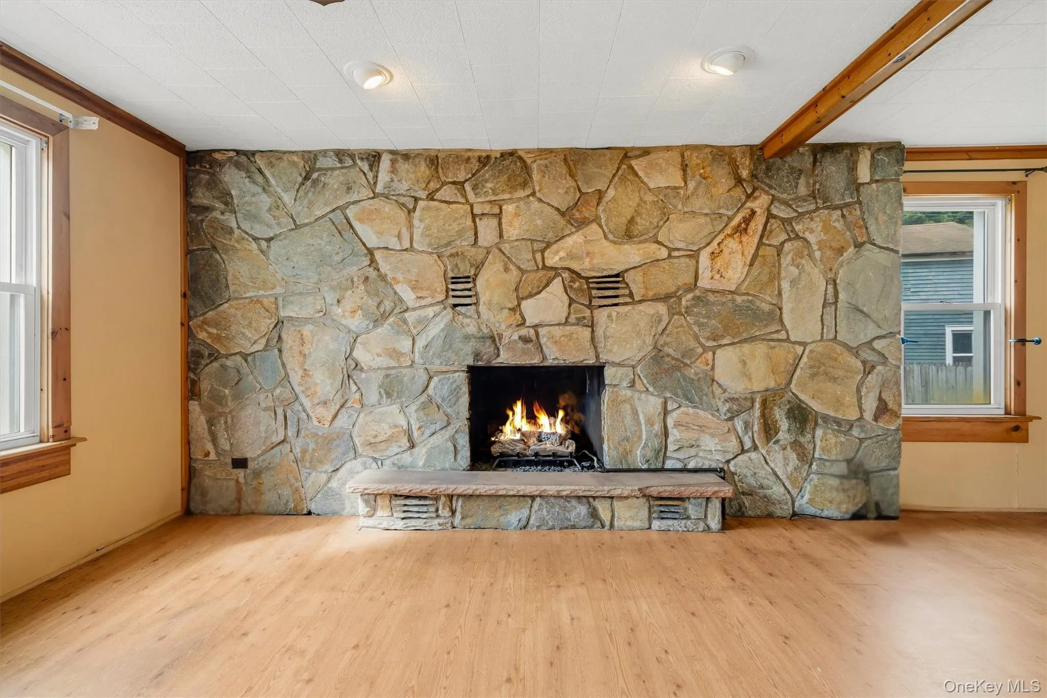 View upon entry of home into the living room with stone fireplace View upon entry of home into the living room with stone fireplace