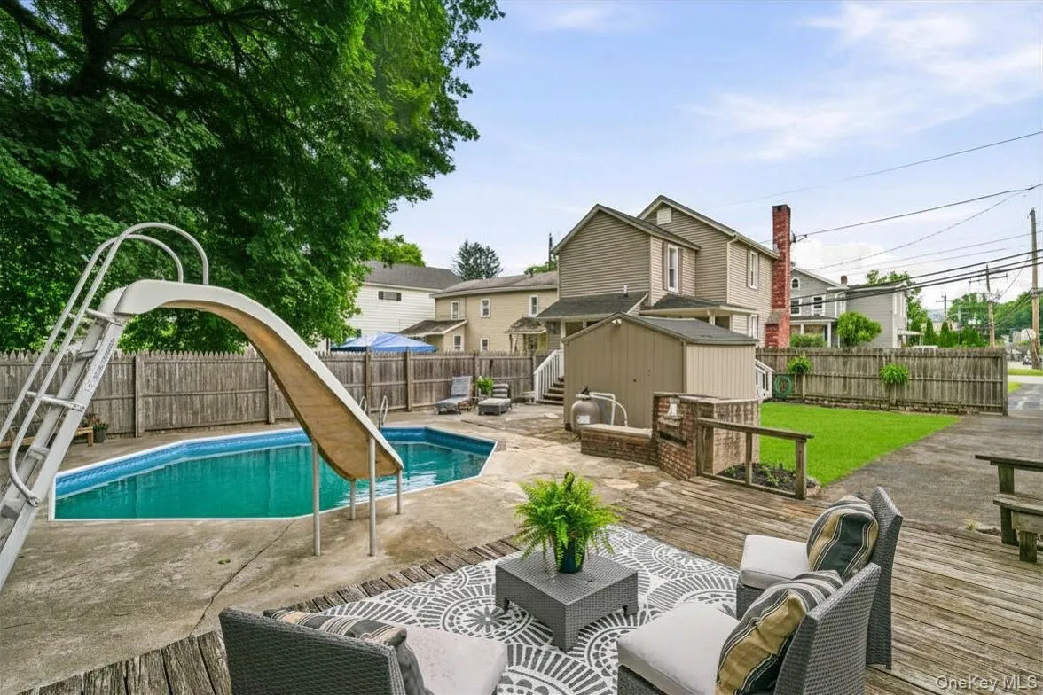Inground pool with slide and seating area Inground pool with slide and seating area