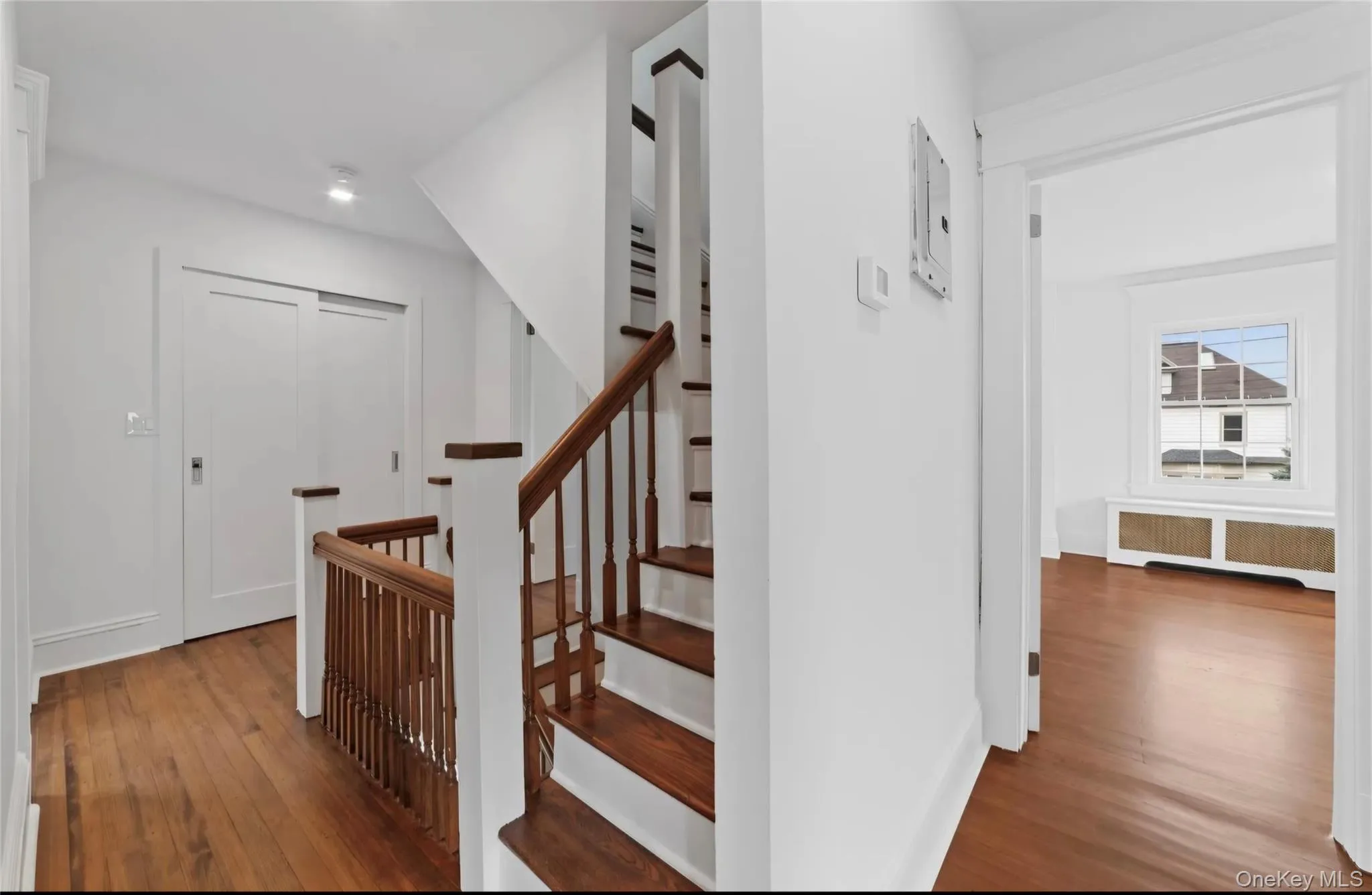 Hardwood flooring throughout, featuring a staircase with wood treads and balusters Hardwood flooring throughout, featuring a staircase with wood treads and balusters