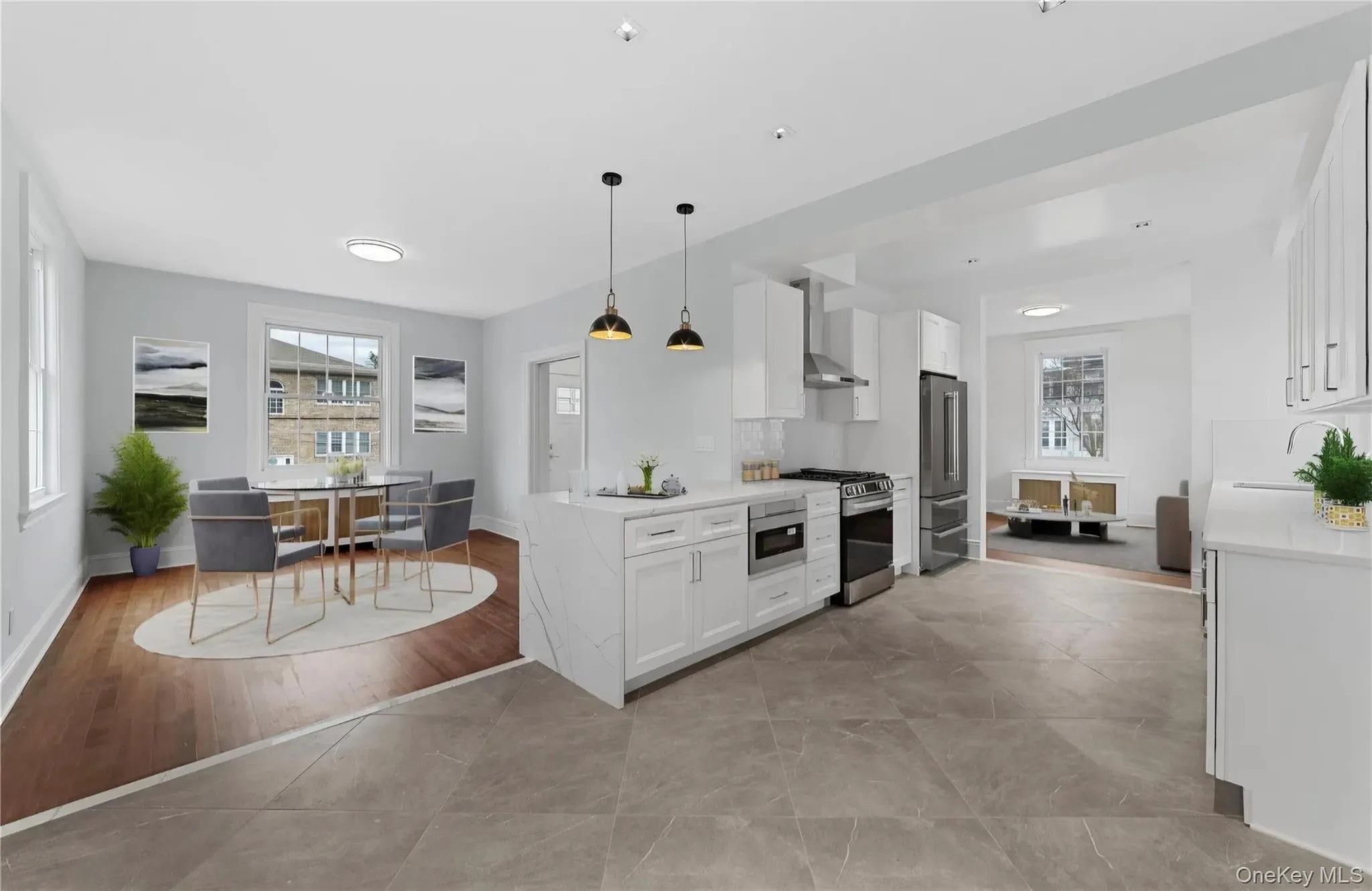 Modern kitchen featuring white cabinetry, stainless steel appliances, and a waterfall-edge island with a stone-finish countertop Modern kitchen featuring white cabinetry, stainless steel appliances, and a waterfall-edge island with a stone-finish countertop
