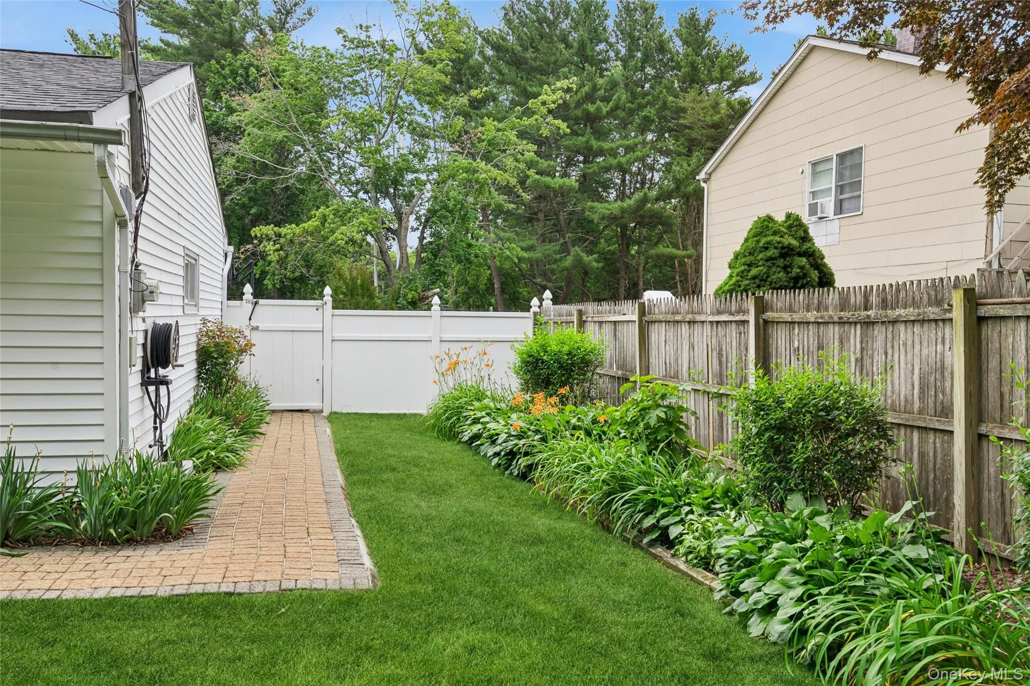 Expansive backyard featuring a manicured lawn and mature plantings Expansive backyard featuring a manicured lawn and mature plantings