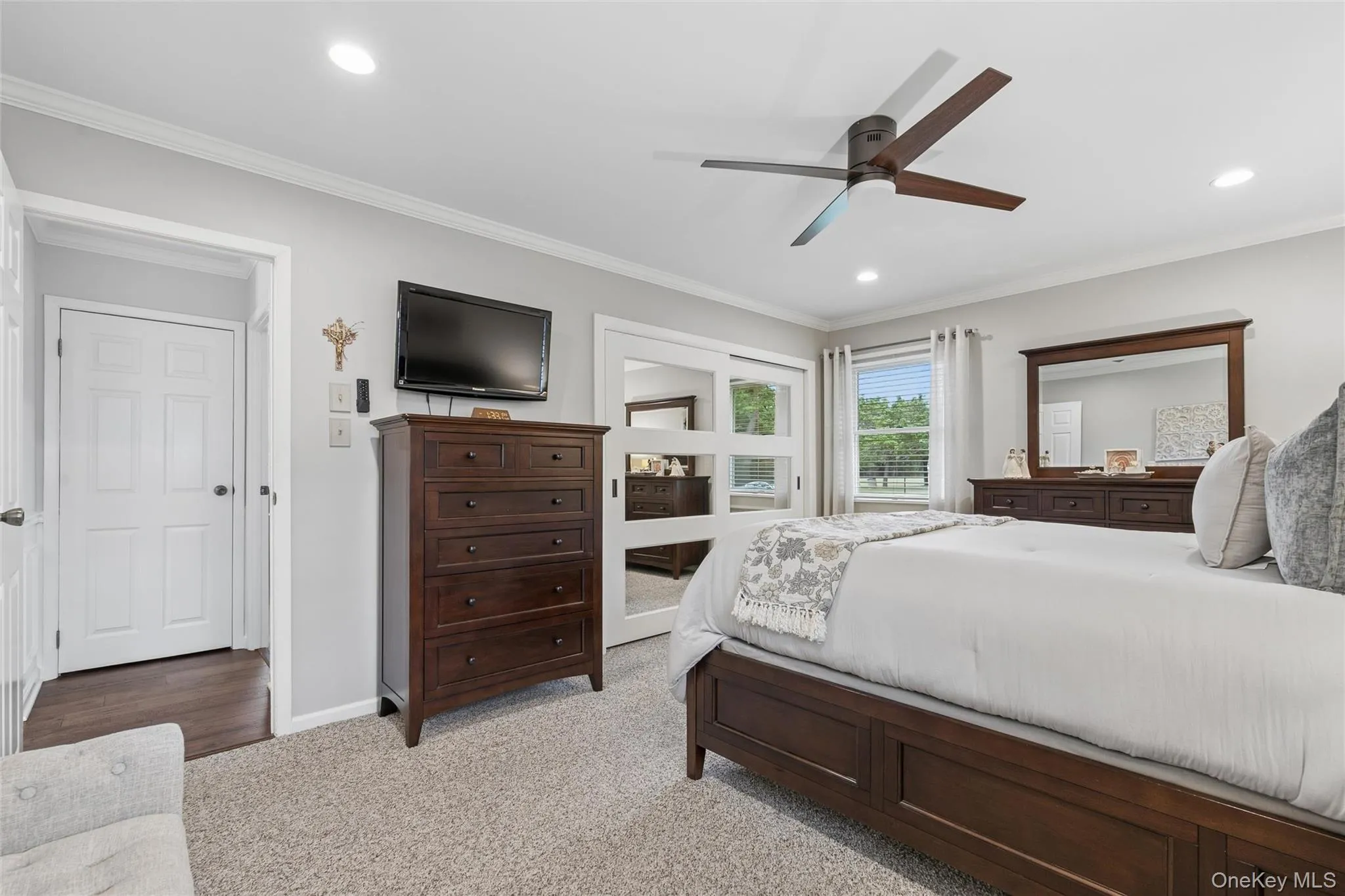 Bedroom featuring light gray walls, white trim, and light-toned carpet Bedroom featuring light gray walls, white trim, and light-toned carpet