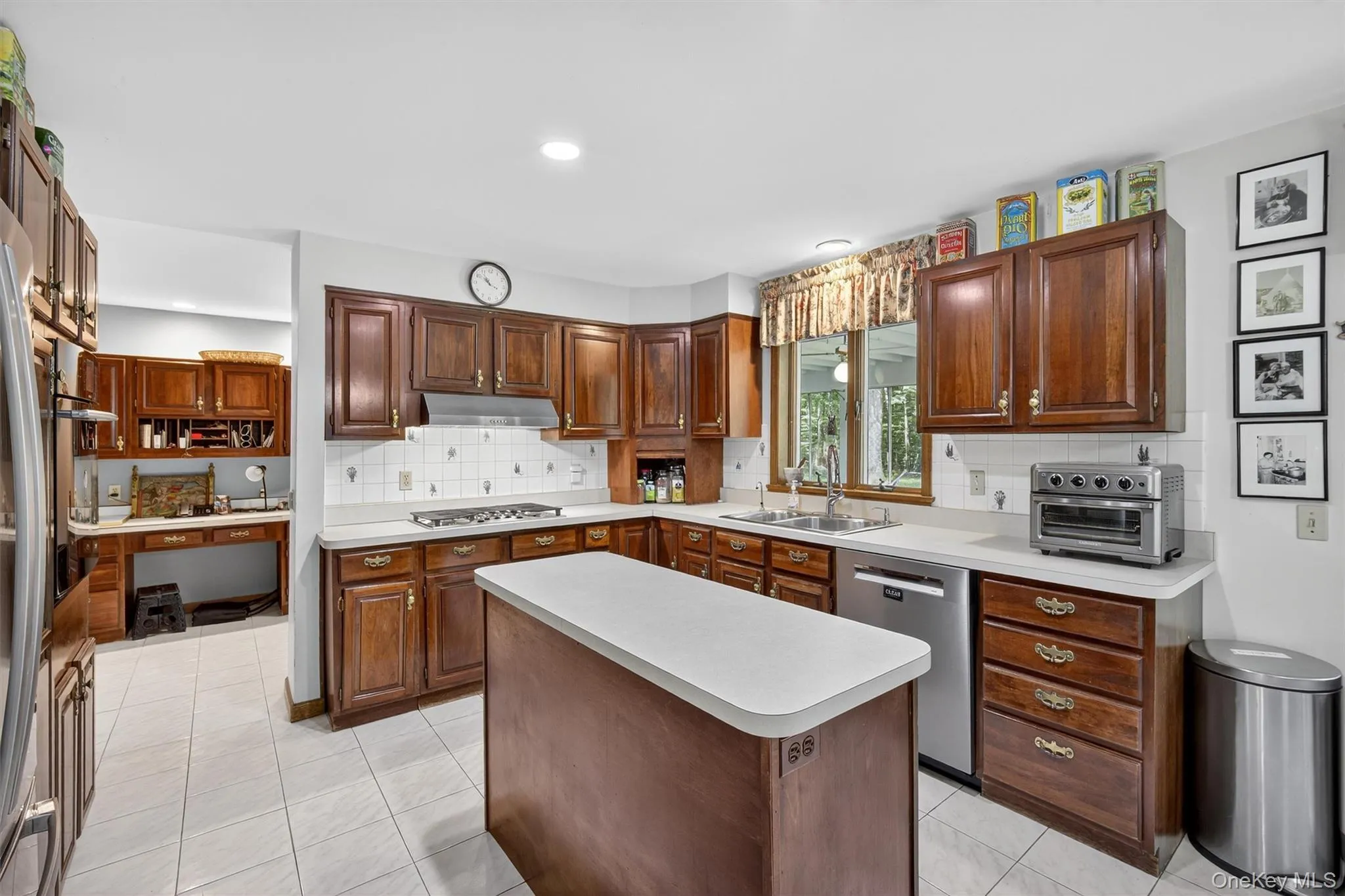 Kitchen with stainless steel appliances, under cabinet range hood, light countertops, backsplash, and recessed lighting Kitchen with stainless steel appliances, under cabinet range hood, light countertops, backsplash, and recessed lighting