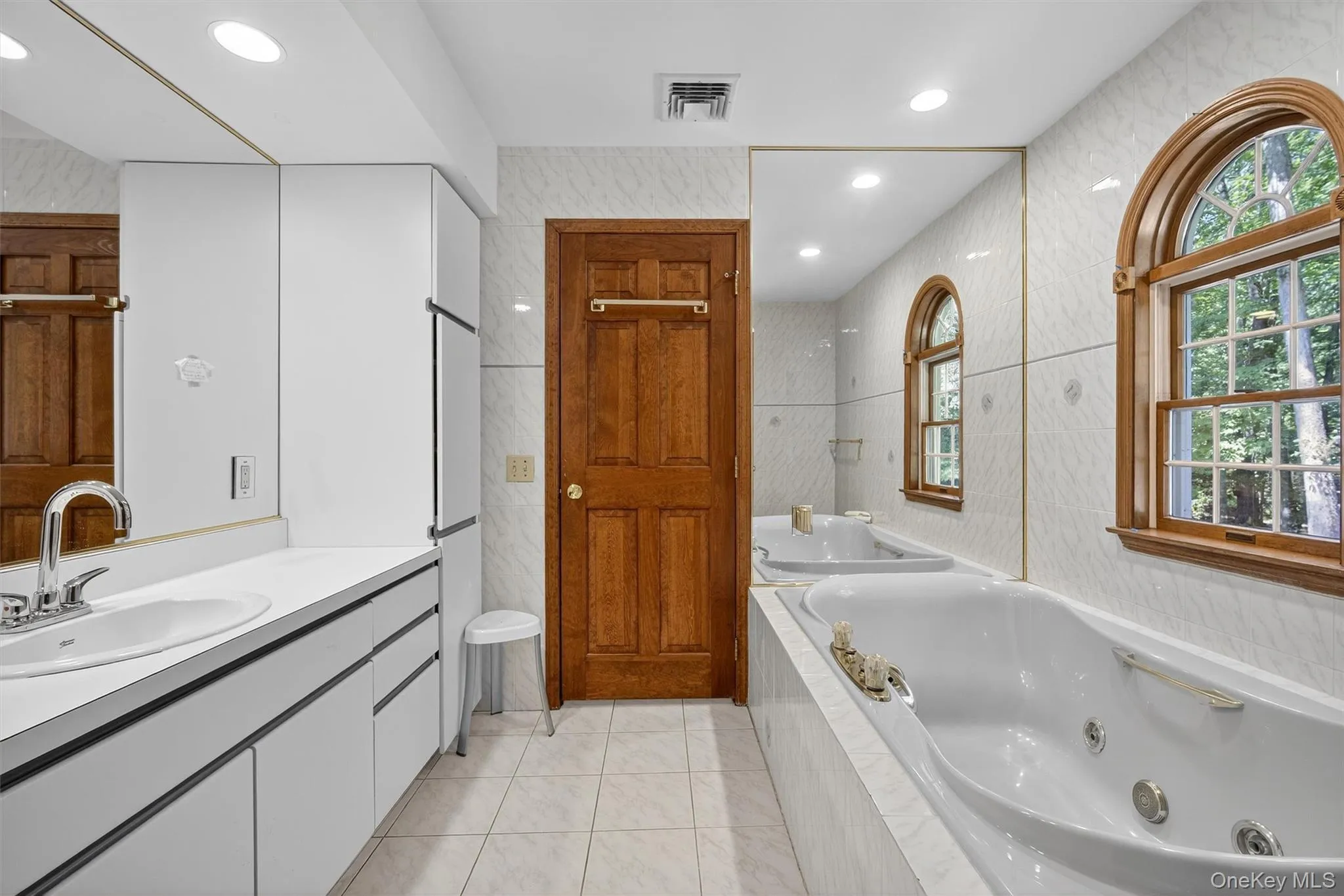 Bathroom featuring vanity, healthy amount of natural light, a whirlpool tub, tile patterned floors, and recessed lighting Bathroom featuring vanity, healthy amount of natural light, a whirlpool tub, tile patterned floors, and recessed lighting