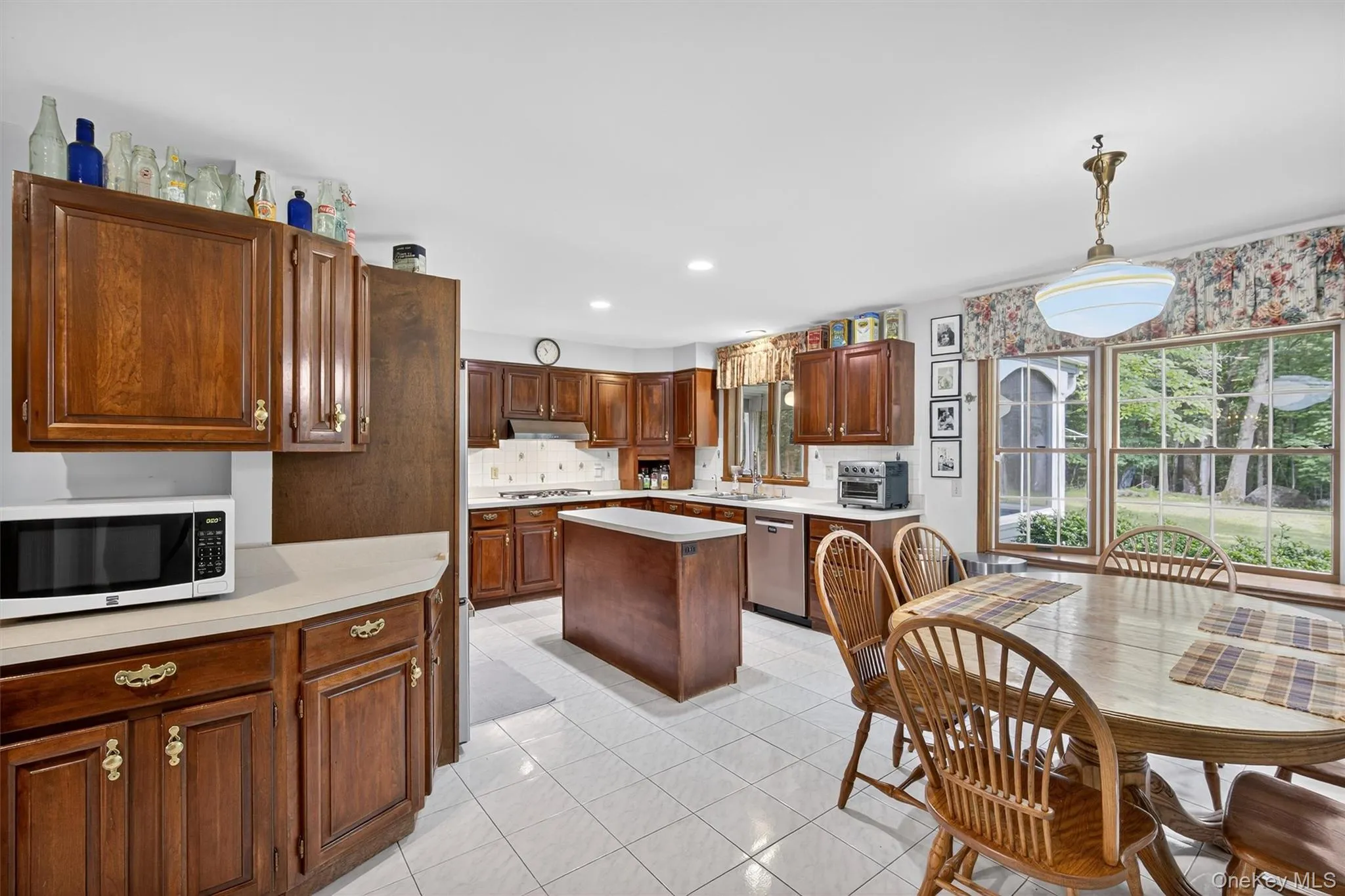 Kitchen with dishwasher, light countertops, light tile patterned floors, gas cooktop, and recessed lighting Kitchen with dishwasher, light countertops, light tile patterned floors, gas cooktop, and recessed lighting