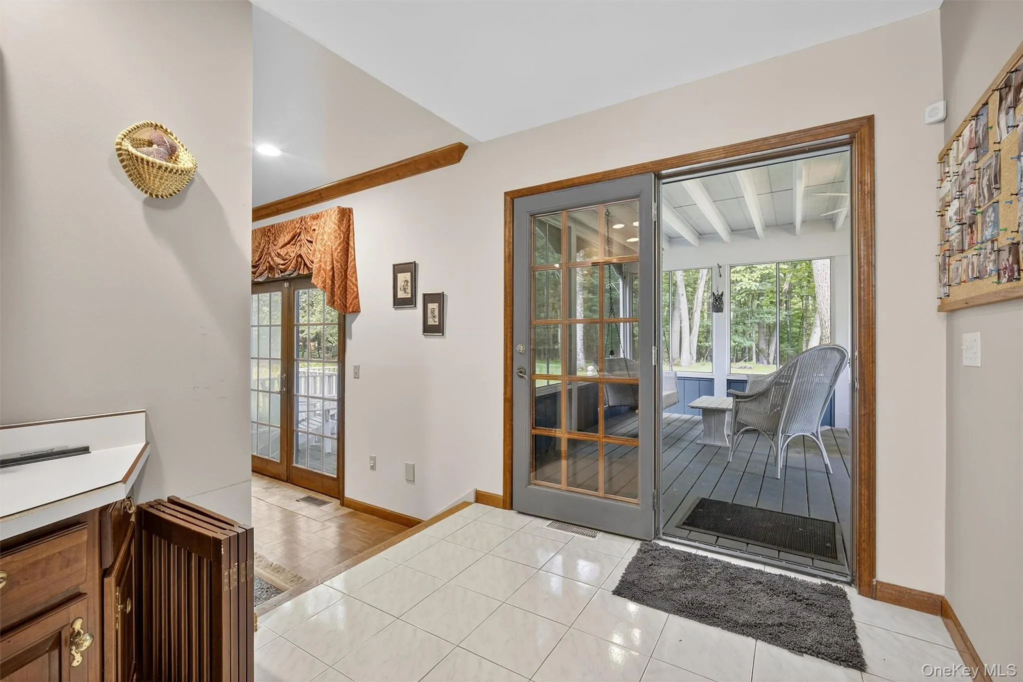 Doorway to outside featuring light tile patterned floors and beam ceiling Doorway to outside featuring light tile patterned floors and beam ceiling