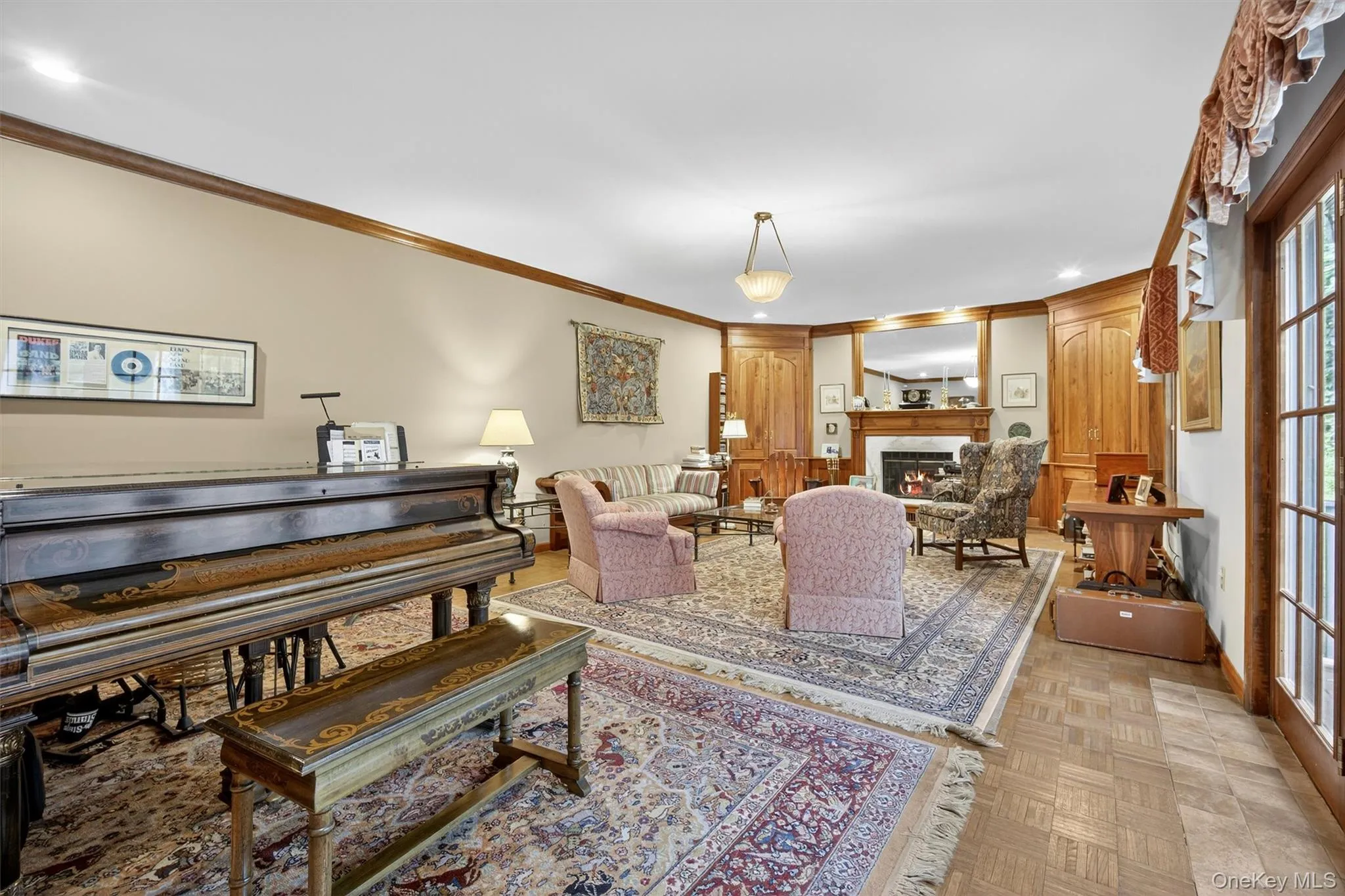 Living room with a warm lit fireplace, ornamental molding, and recessed lighting Living room with a warm lit fireplace, ornamental molding, and recessed lighting