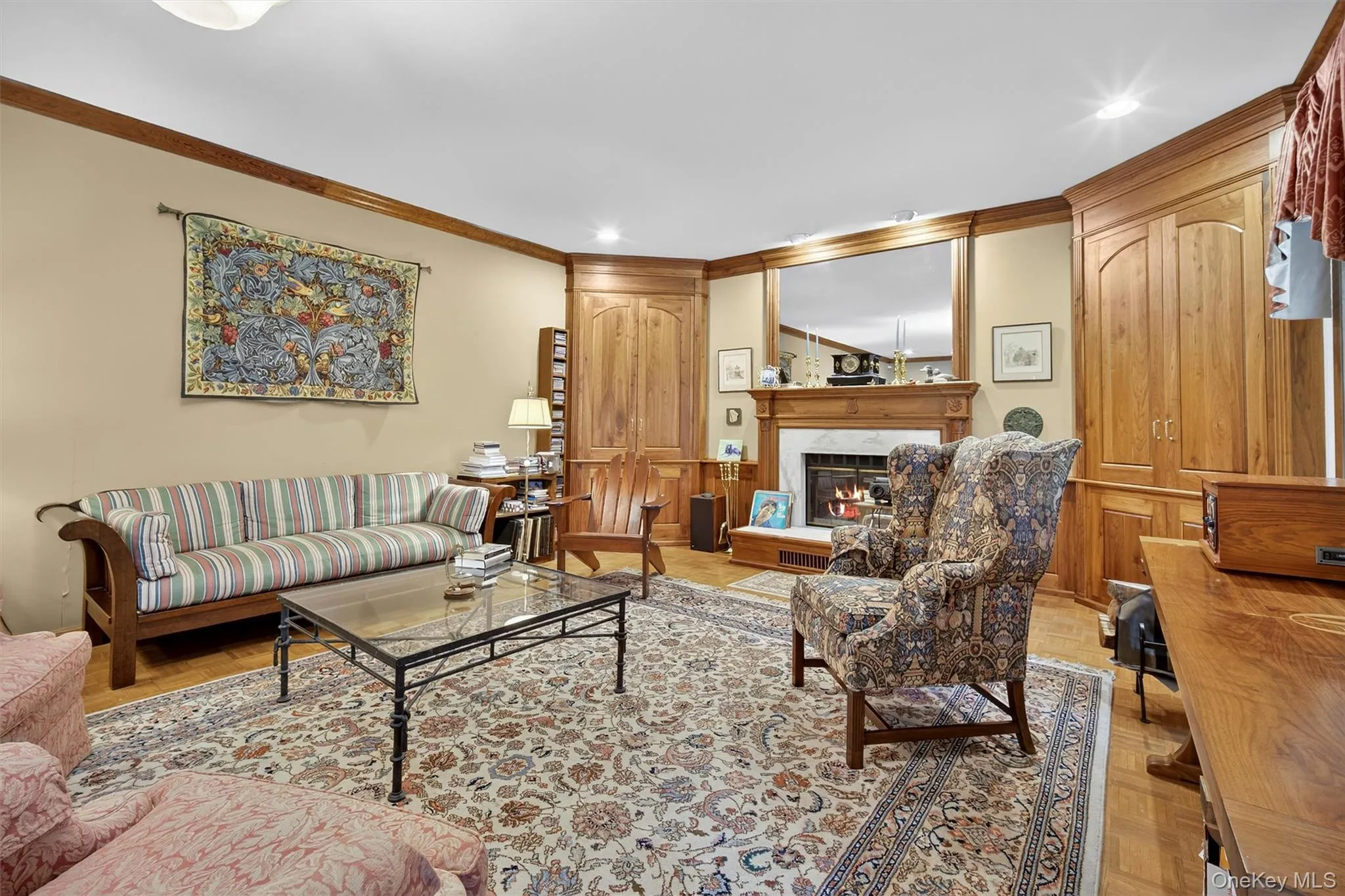 Living area featuring a glass covered fireplace, crown molding, and recessed lighting Living area featuring a glass covered fireplace, crown molding, and recessed lighting