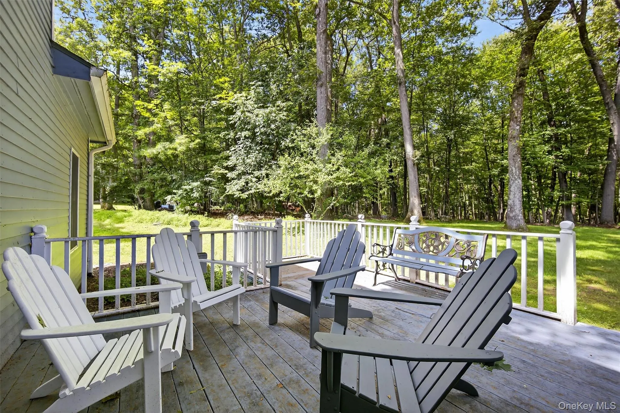 Wooden deck featuring a lawn and view of wooded area Wooden deck featuring a lawn and view of wooded area
