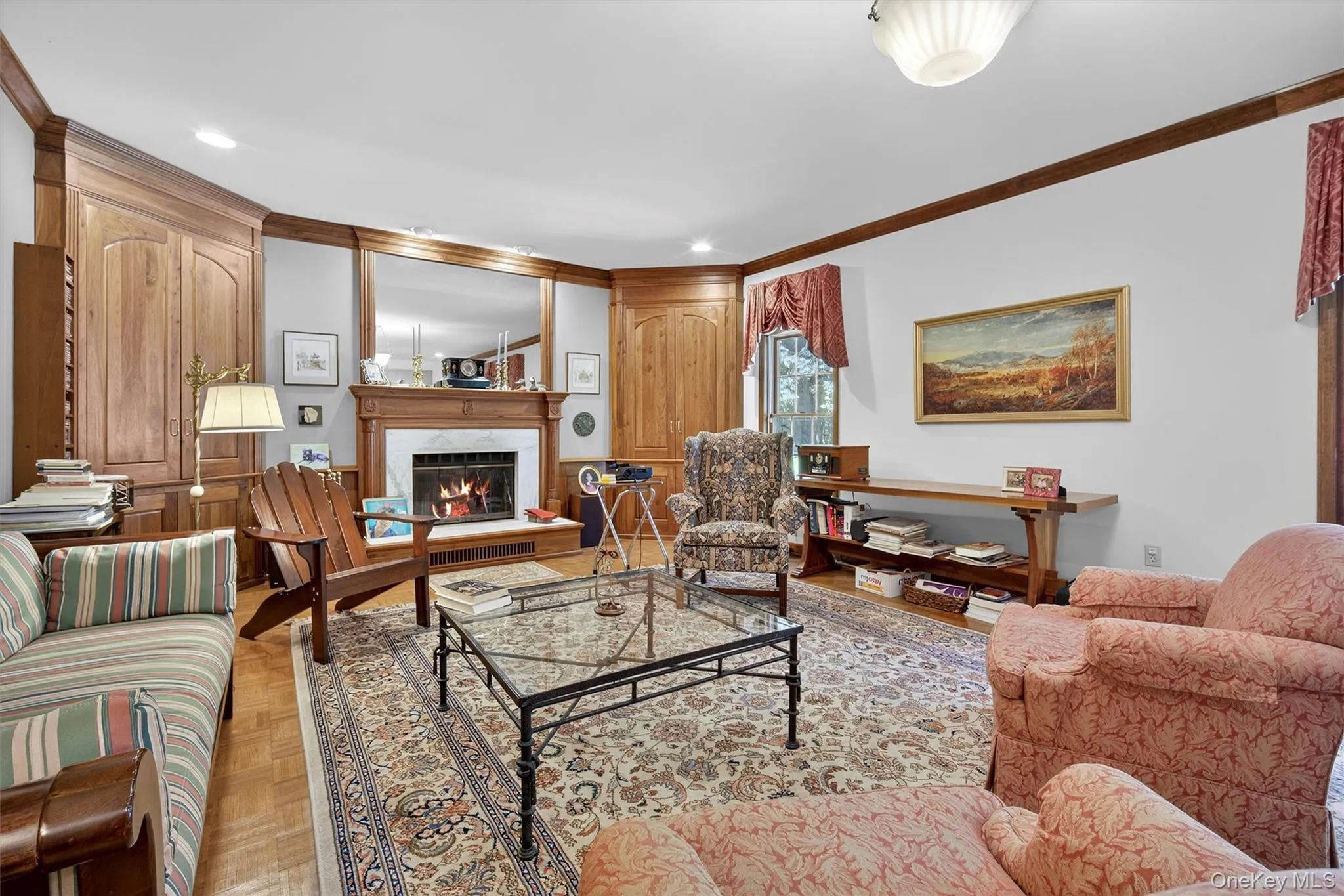 Living area featuring crown molding, a lit fireplace, and recessed lighting Living area featuring crown molding, a lit fireplace, and recessed lighting