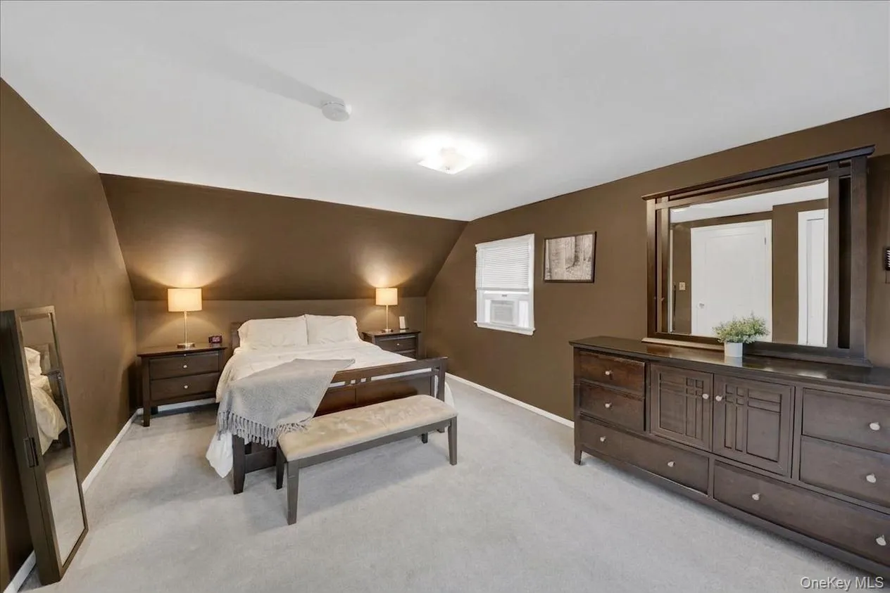 2nd floor bedroom featuring vaulted ceilings, soft gray wall-to-wall carpeting, and a built-in window unit 2nd floor bedroom featuring vaulted ceilings, soft gray wall-to-wall carpeting, and a built-in window unit