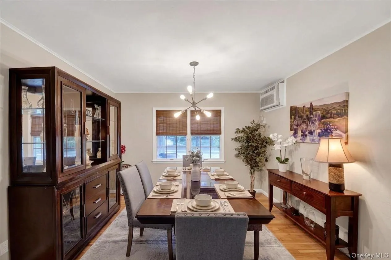 Dining area featuring wood-finish flooring, neutral wall tones, and a modern sputnik chandelier Dining area featuring wood-finish flooring, neutral wall tones, and a modern sputnik chandelier