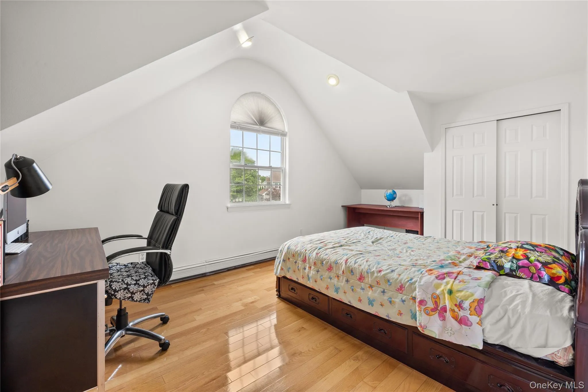 Bedroom featuring wood-finish flooring and sloped ceilings with recessed lighting Bedroom featuring wood-finish flooring and sloped ceilings with recessed lighting