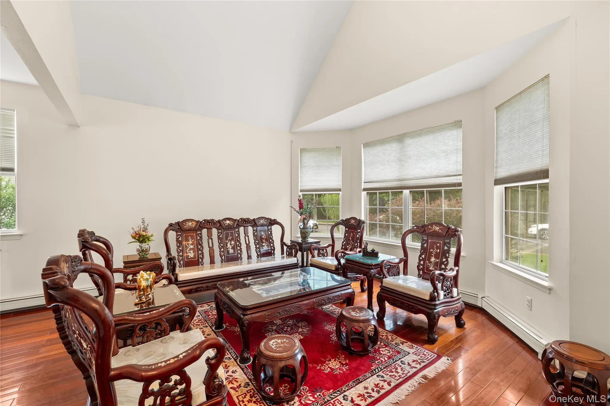Living room with vaulted ceiling living space featuring rich wood-finish flooring Living room with vaulted ceiling living space featuring rich wood-finish flooring