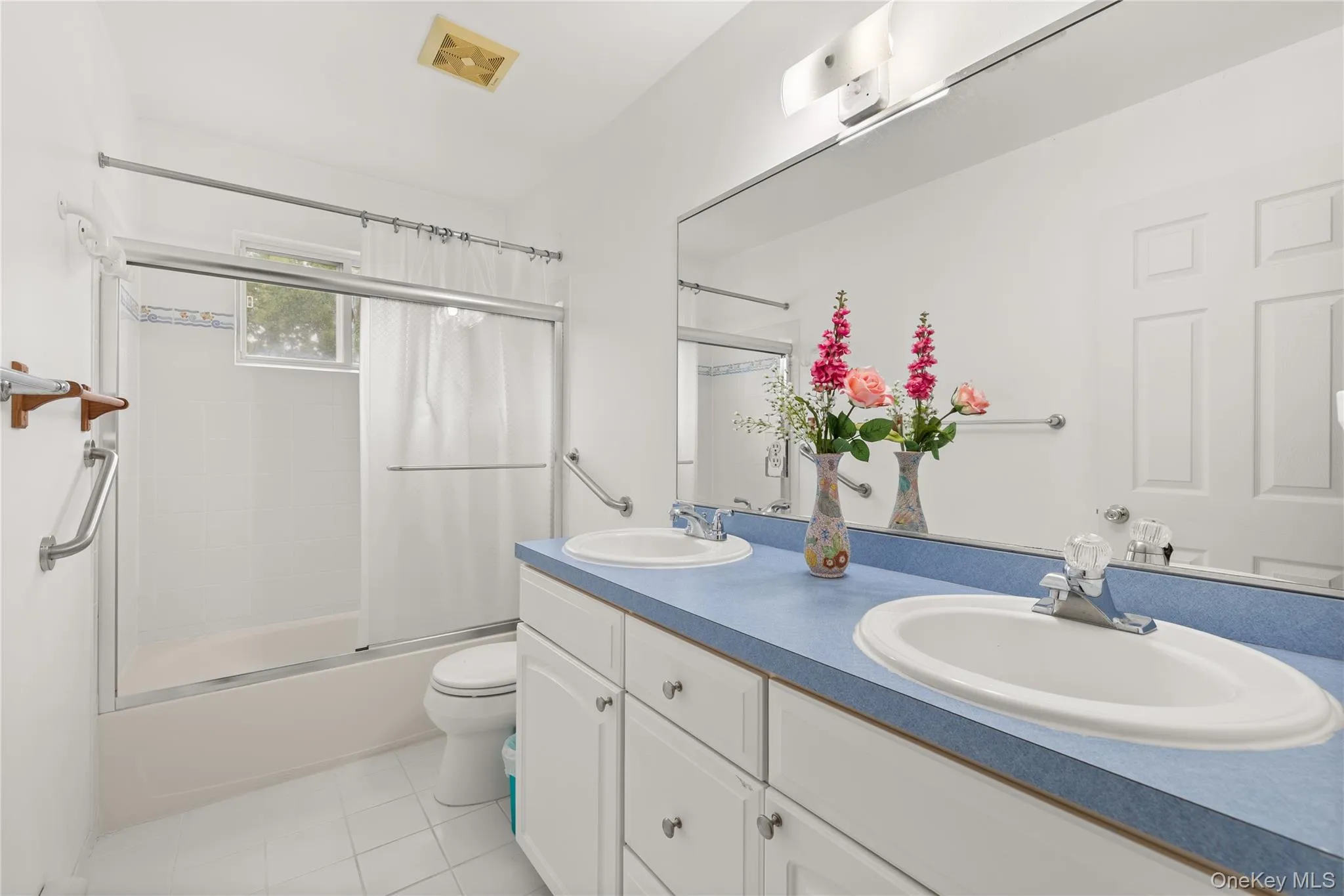 Upstairs bathroom featuring a dual vanity with a blue countertop, white cabinetry, and two undermount sinks Upstairs bathroom featuring a dual vanity with a blue countertop, white cabinetry, and two undermount sinks