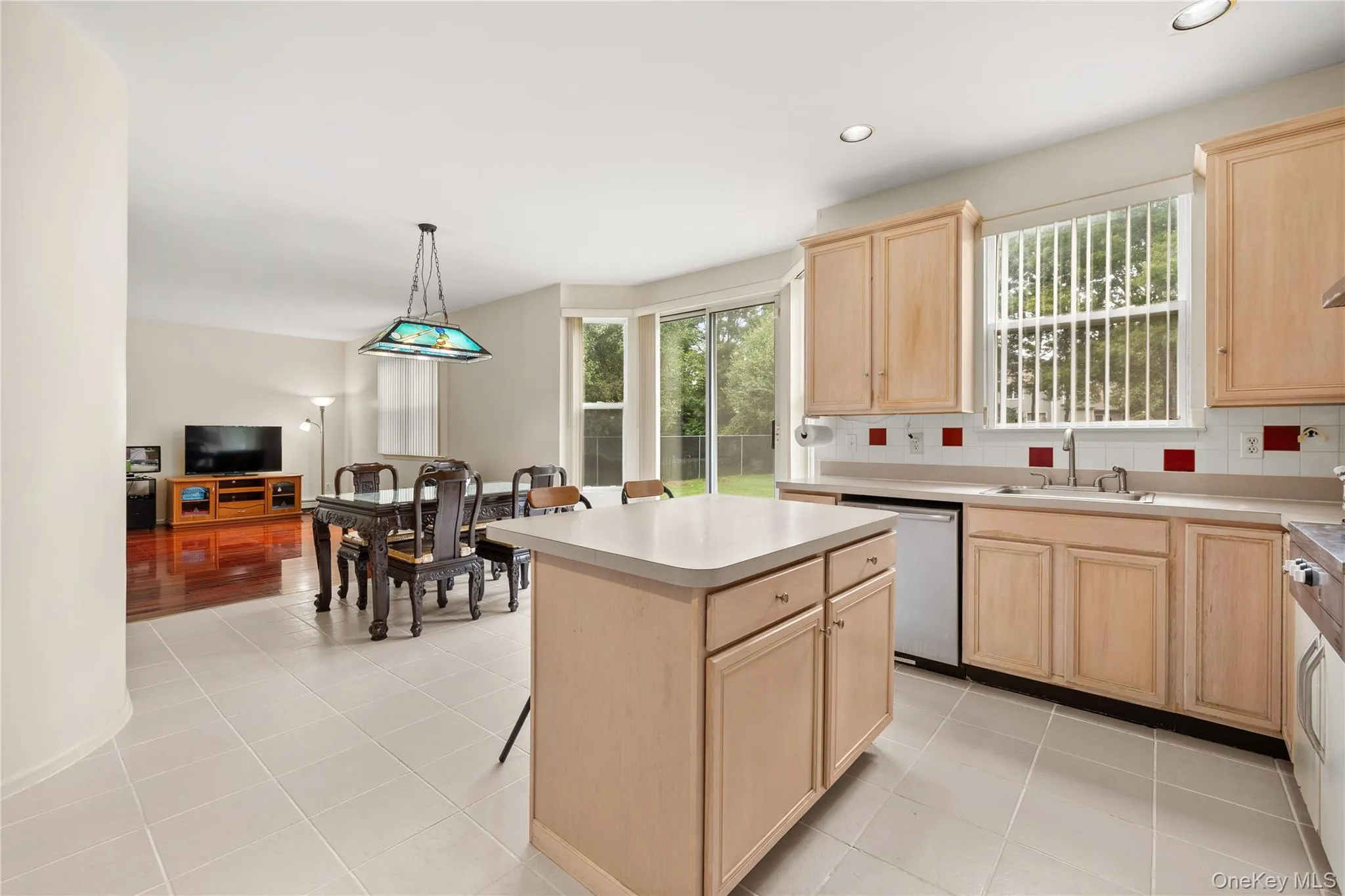Kitchen featuring a central island, light wood-finish cabinetry, tile flooring Kitchen featuring a central island, light wood-finish cabinetry, tile flooring