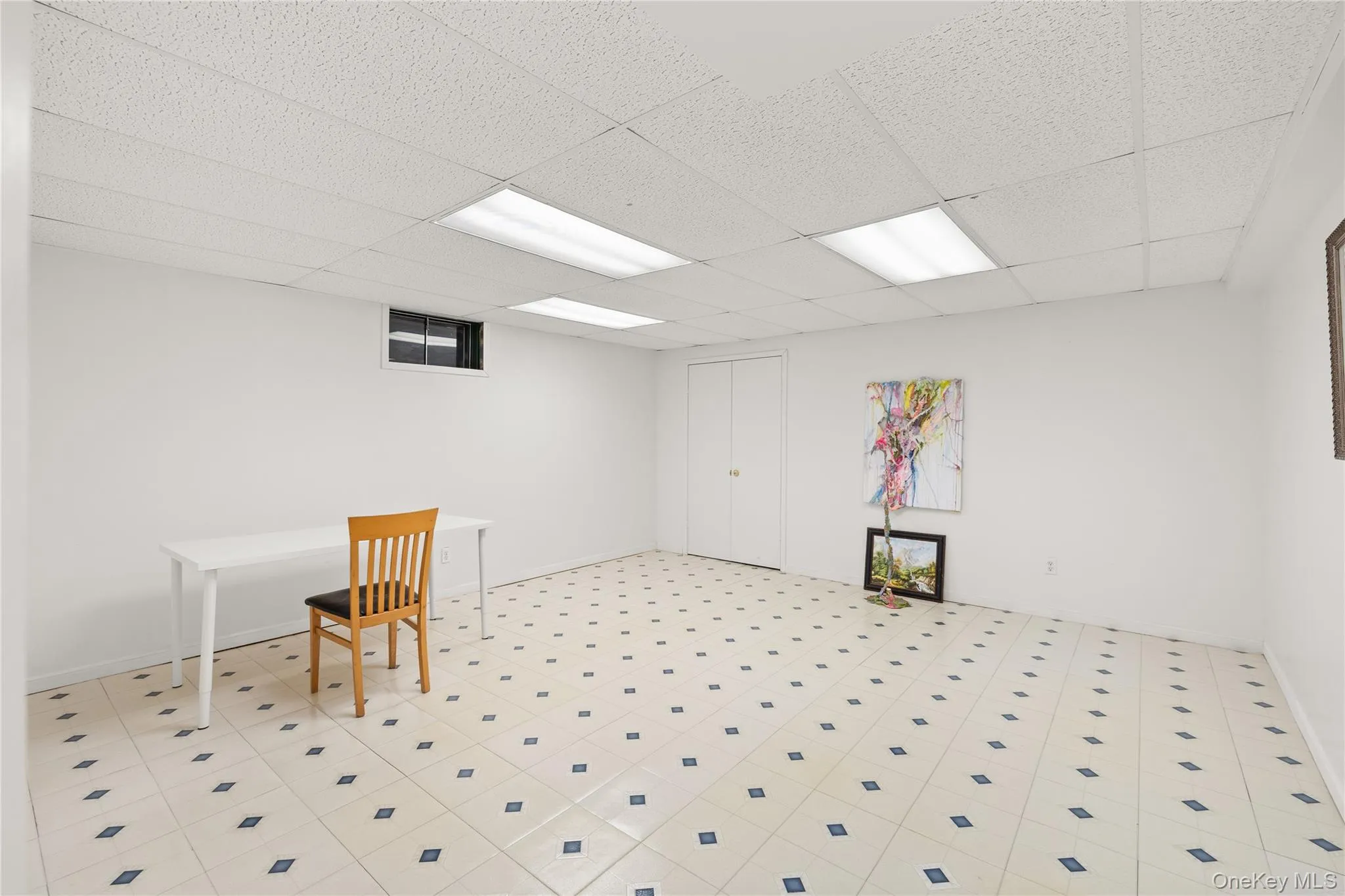 Finished basement with 3 rooms featuring white painted walls and a tile floor with a diamond pattern Finished basement with 3 rooms featuring white painted walls and a tile floor with a diamond pattern