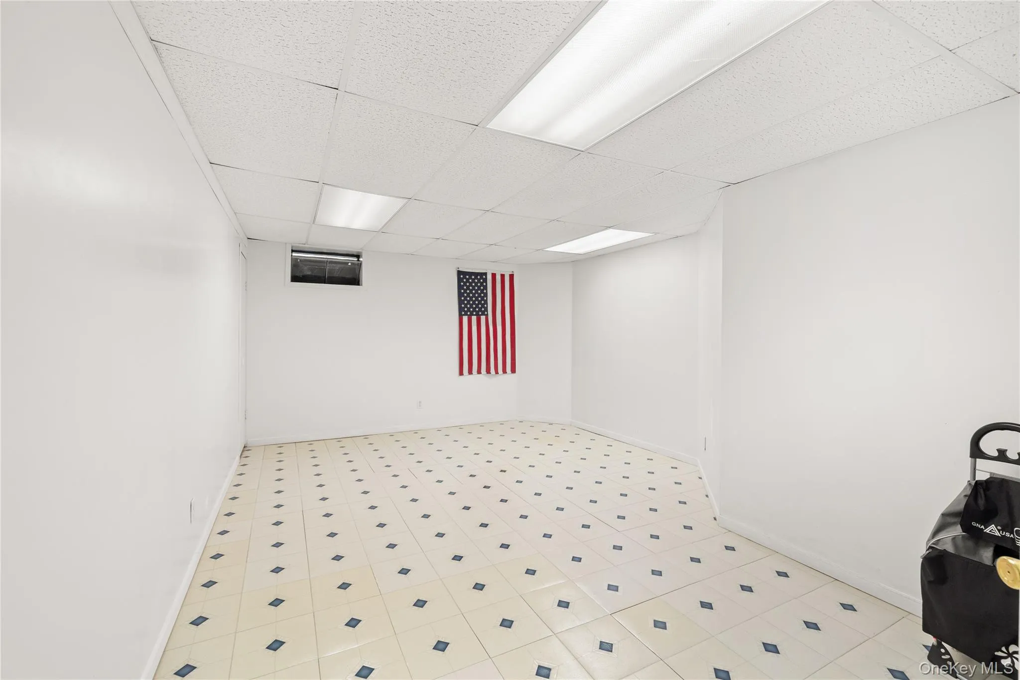 Finished basement with 3 rooms featuring white painted walls and a tile floor with a diamond pattern Finished basement with 3 rooms featuring white painted walls and a tile floor with a diamond pattern