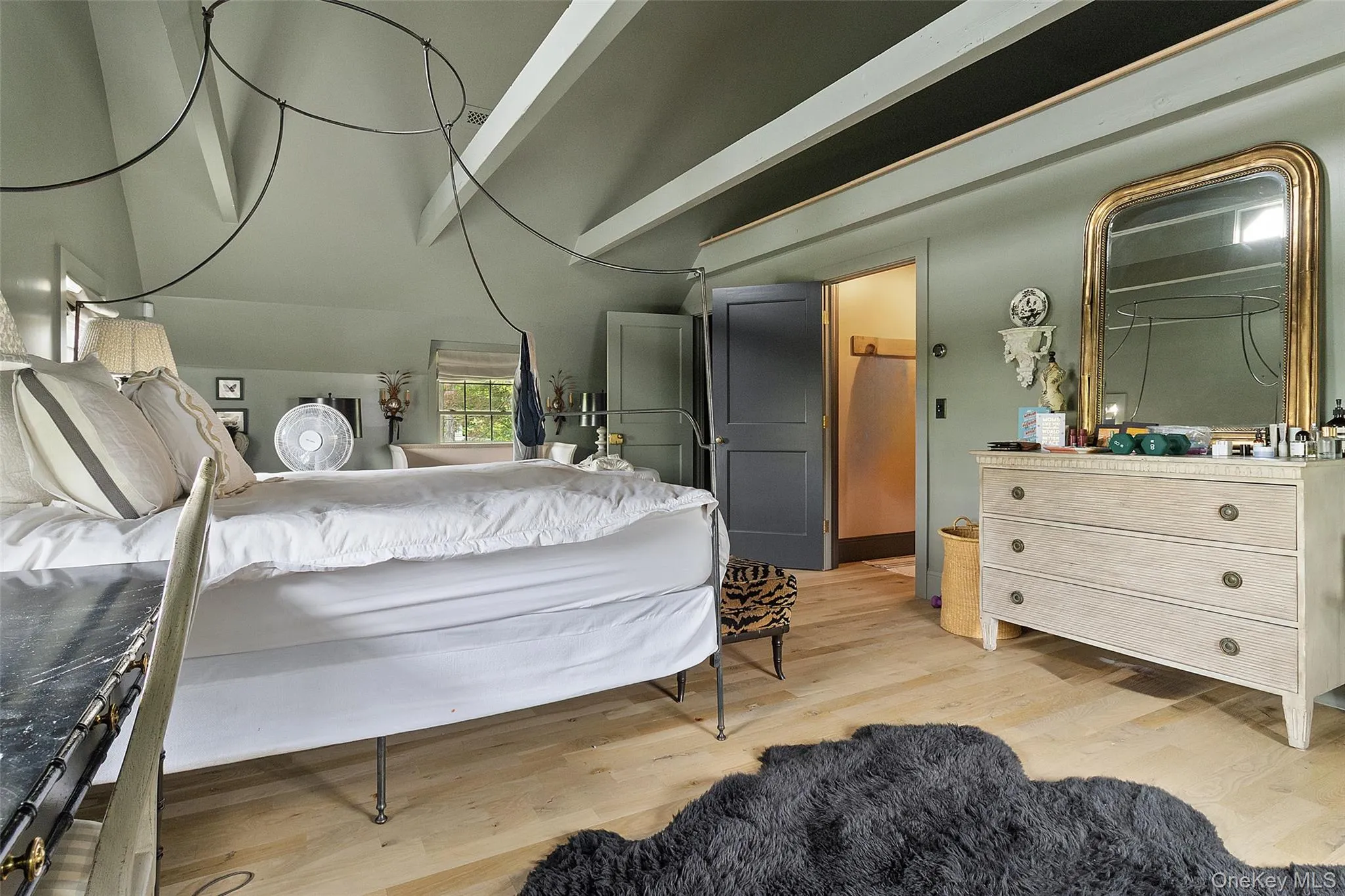 Bedroom featuring light wood-type flooring and beam ceiling Bedroom featuring light wood-type flooring and beam ceiling
