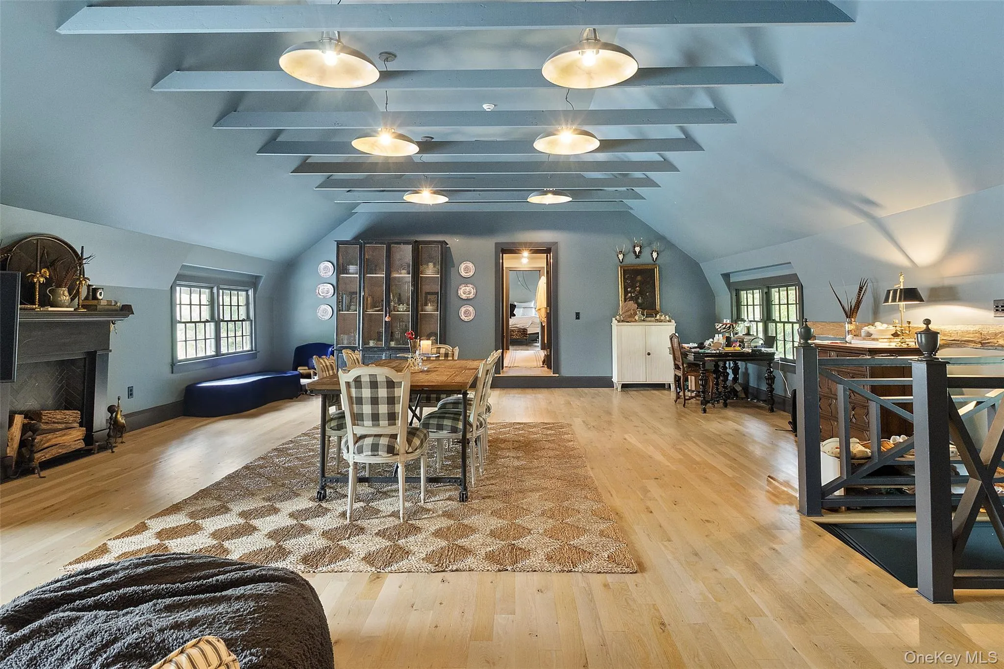 Dining area featuring light wood-style flooring, healthy amount of natural light, and a fireplace Dining area featuring light wood-style flooring, healthy amount of natural light, and a fireplace