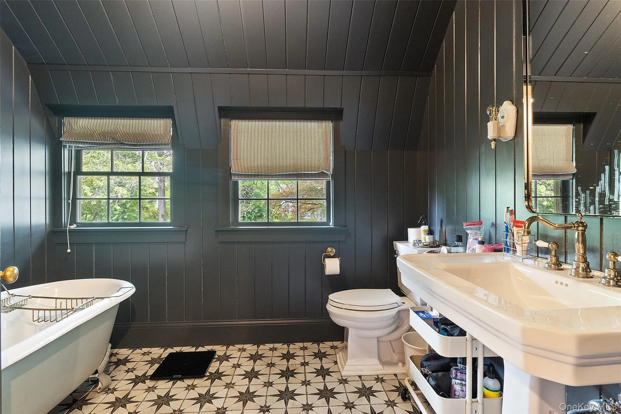 Full bathroom with a soaking tub, plenty of natural light, and wooden walls Full bathroom with a soaking tub, plenty of natural light, and wooden walls