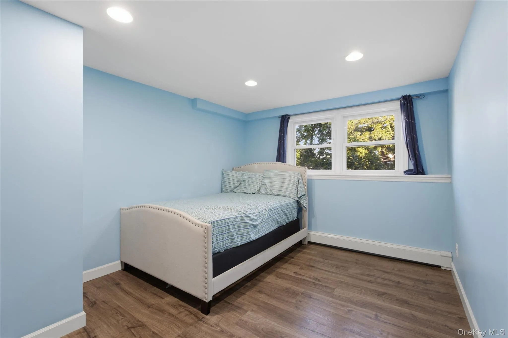 Wood-finish flooring and recessed lighting illuminate this bright room Wood-finish flooring and recessed lighting illuminate this bright room