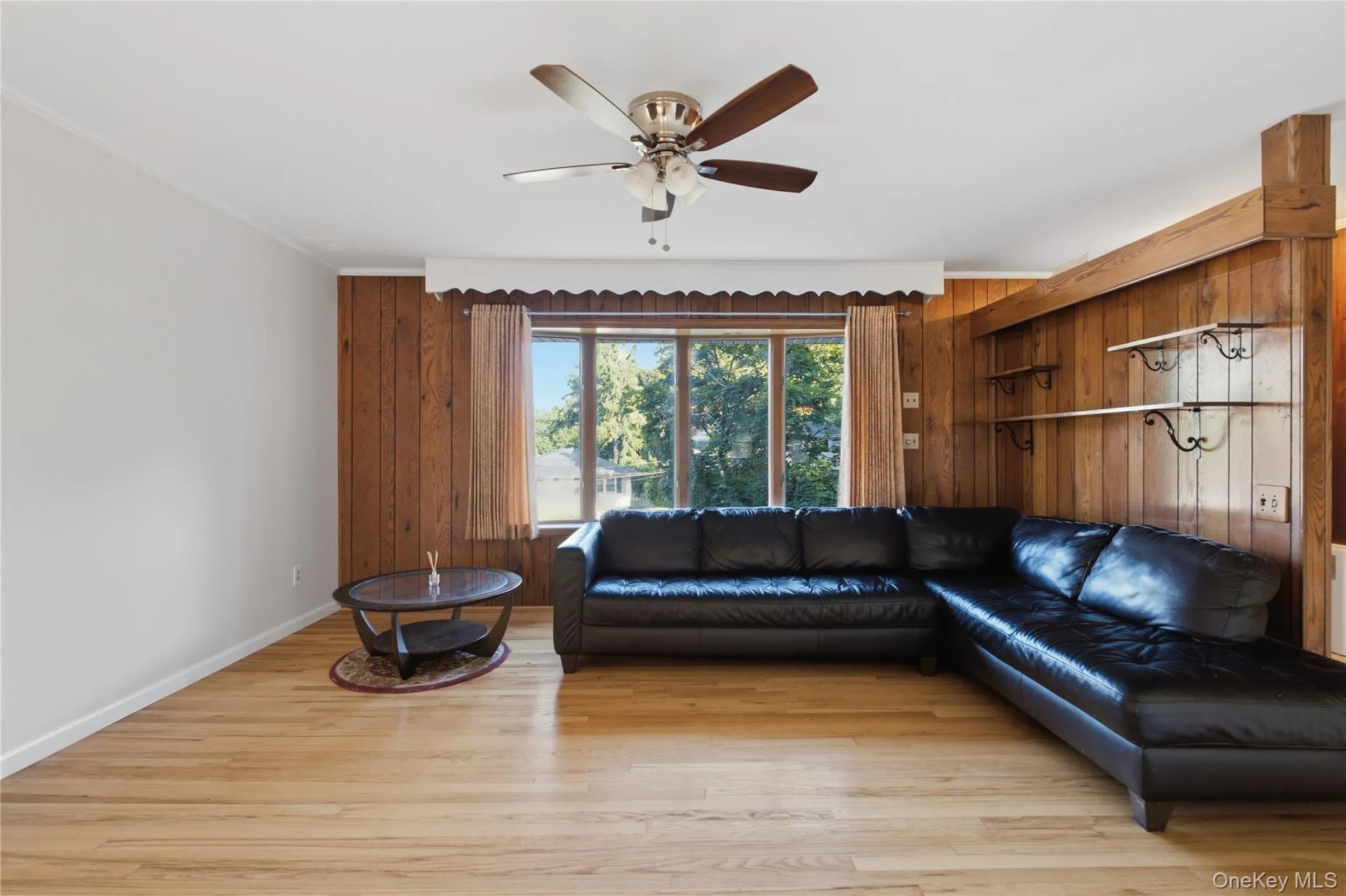 Living area featuring warm wood-paneling and light wood-finish flooring Living area featuring warm wood-paneling and light wood-finish flooring